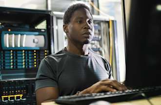 [Featured image] A cybersecurity analyst sits at their desk and studies for the CISSP certification exam.