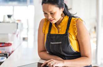 [Featured Image] A business owner analyzes retail analytics on her tablet.