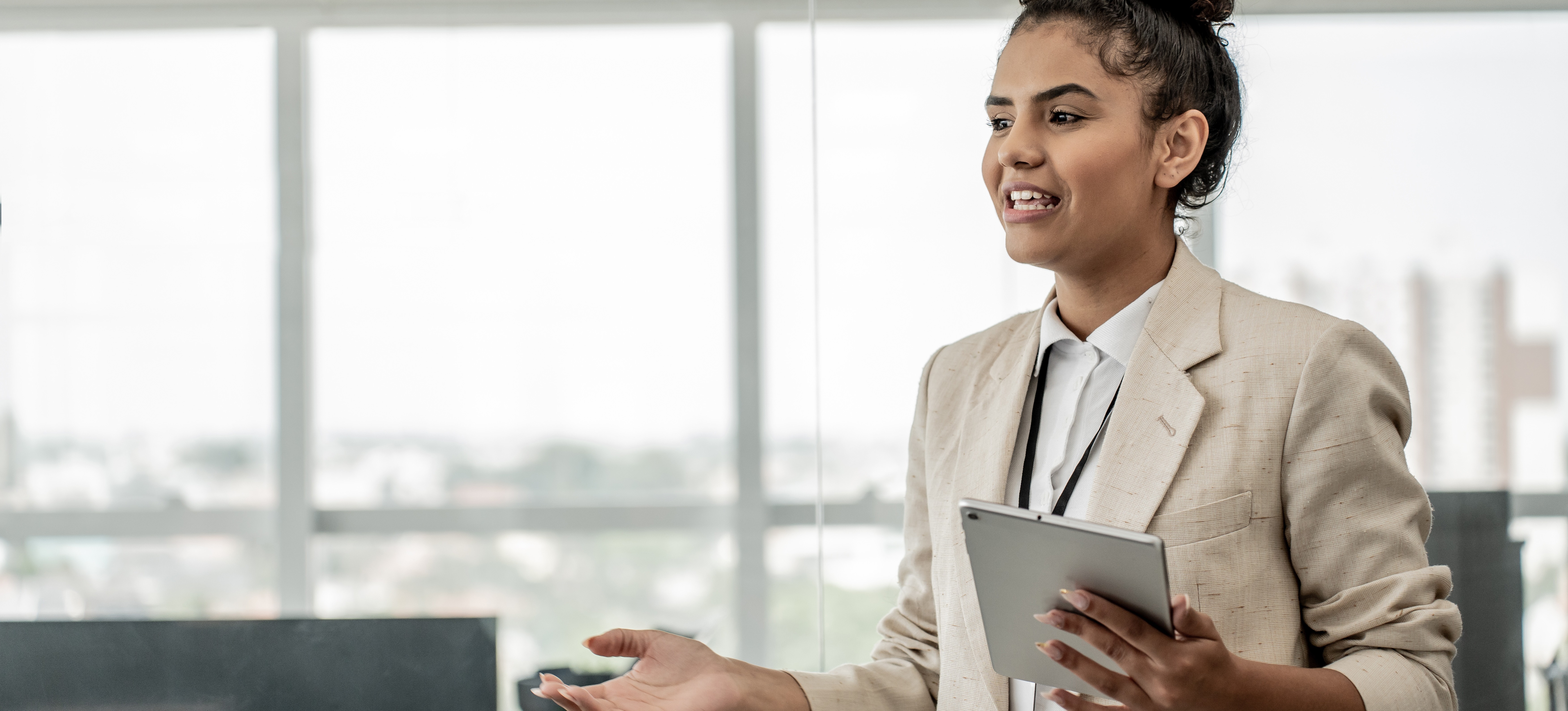 [Featured image] A data protection officer holds a tablet and talks to employees about the importance of data compliance. 