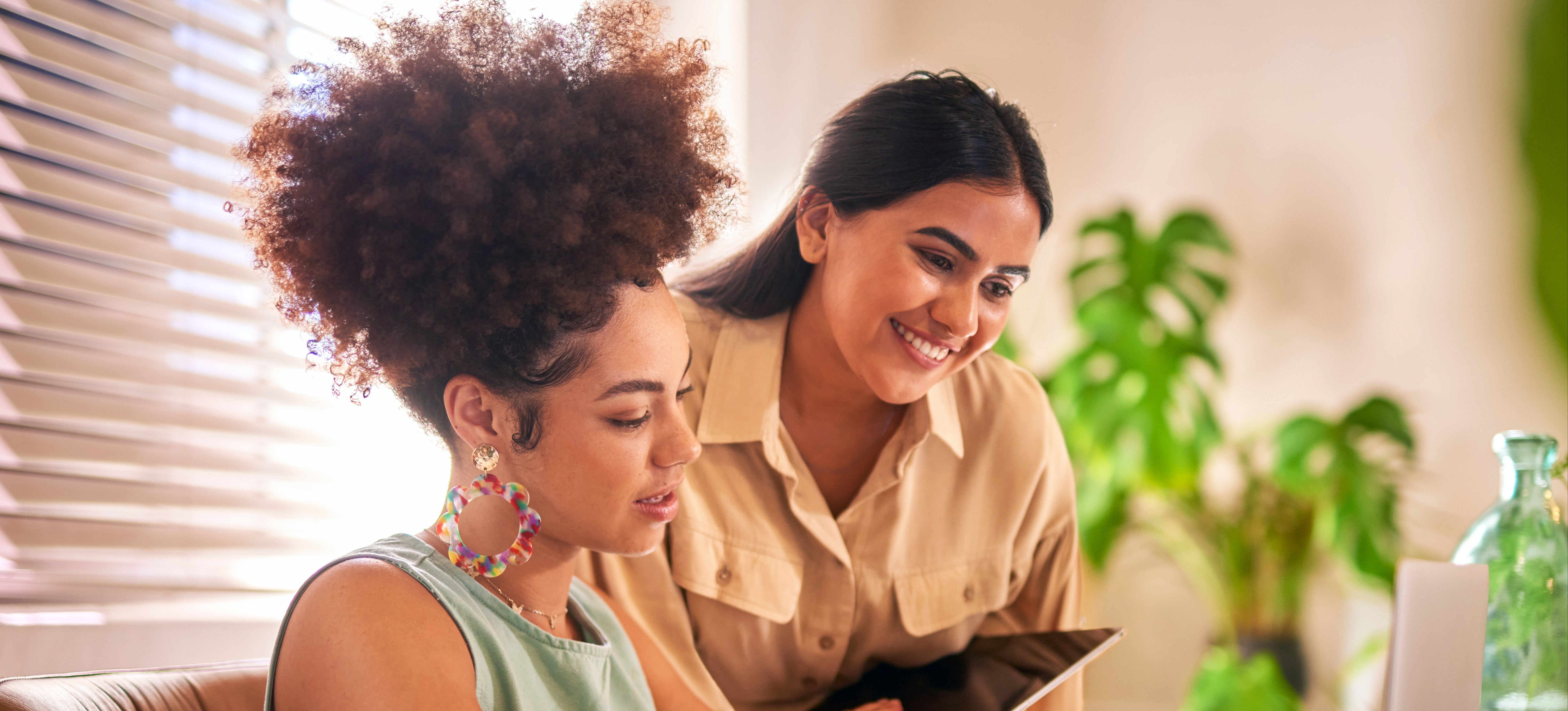 [Featured Image] Two professionals look at a laptop and discuss what operating system is best for their business.   