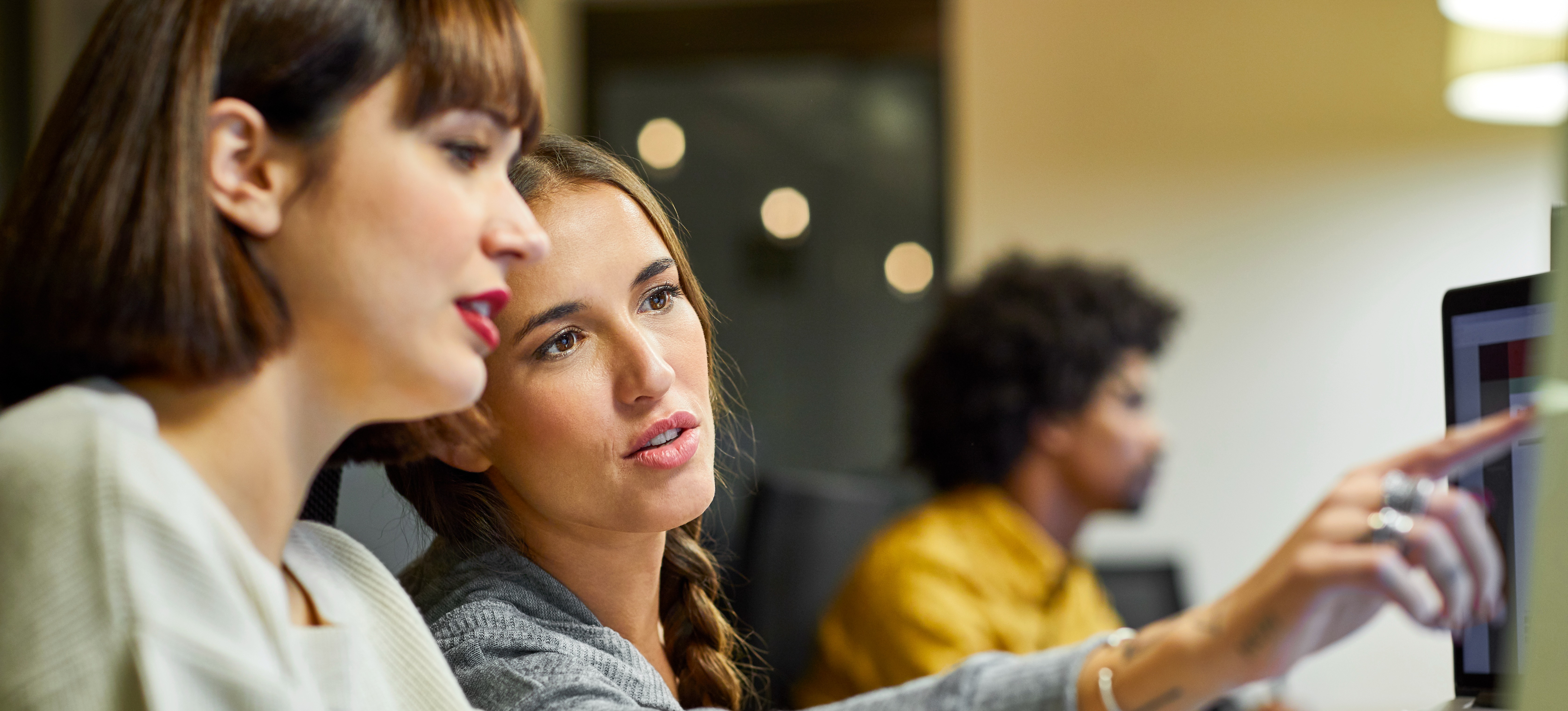 [Featured Image] Two aspiring program managers study together on computers while preparing for program manager certification.
