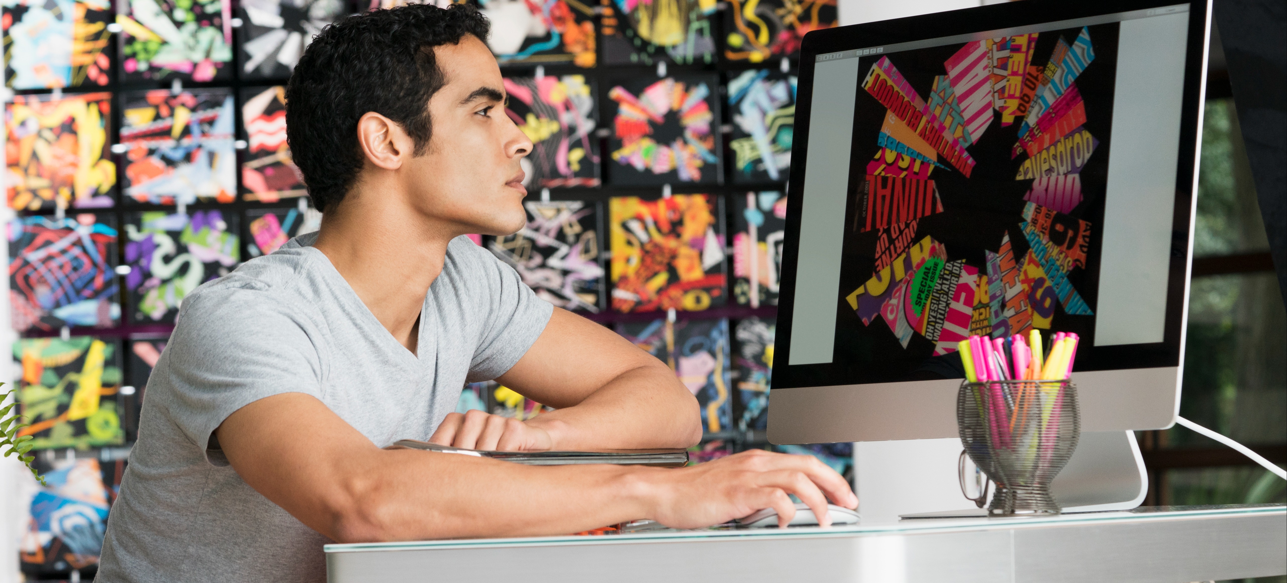 [Featured image] A graphic artist creates colorful digital artwork on his computer after learning how to sell NFTs.