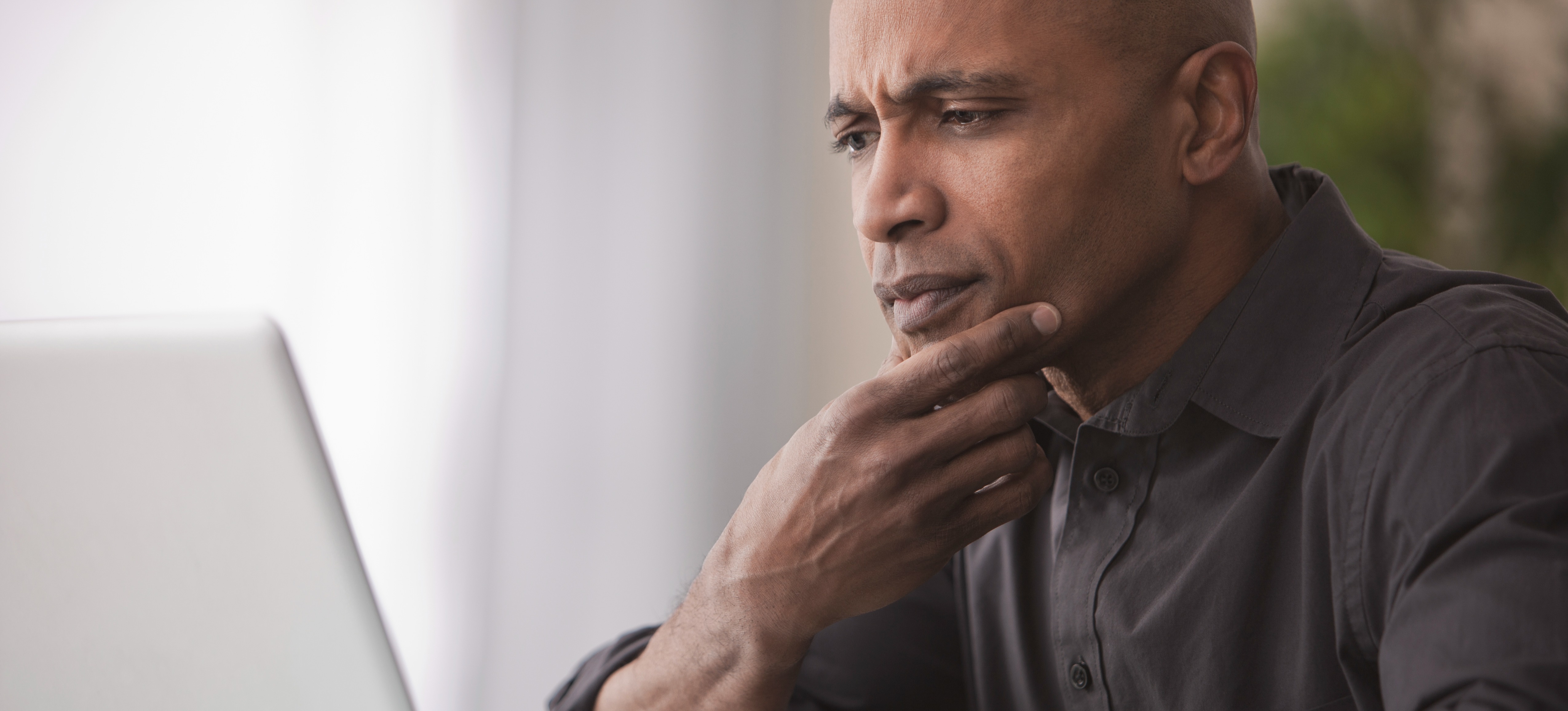 [Feature Image] A generative AI user researches ChatGPT alternatives and compares them on their laptop.
