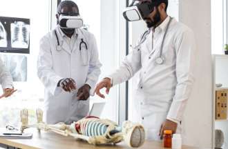 [Featured Image] A group of doctors uses mixed reality to study the human skeletal system using a skeleton model and VR goggles.