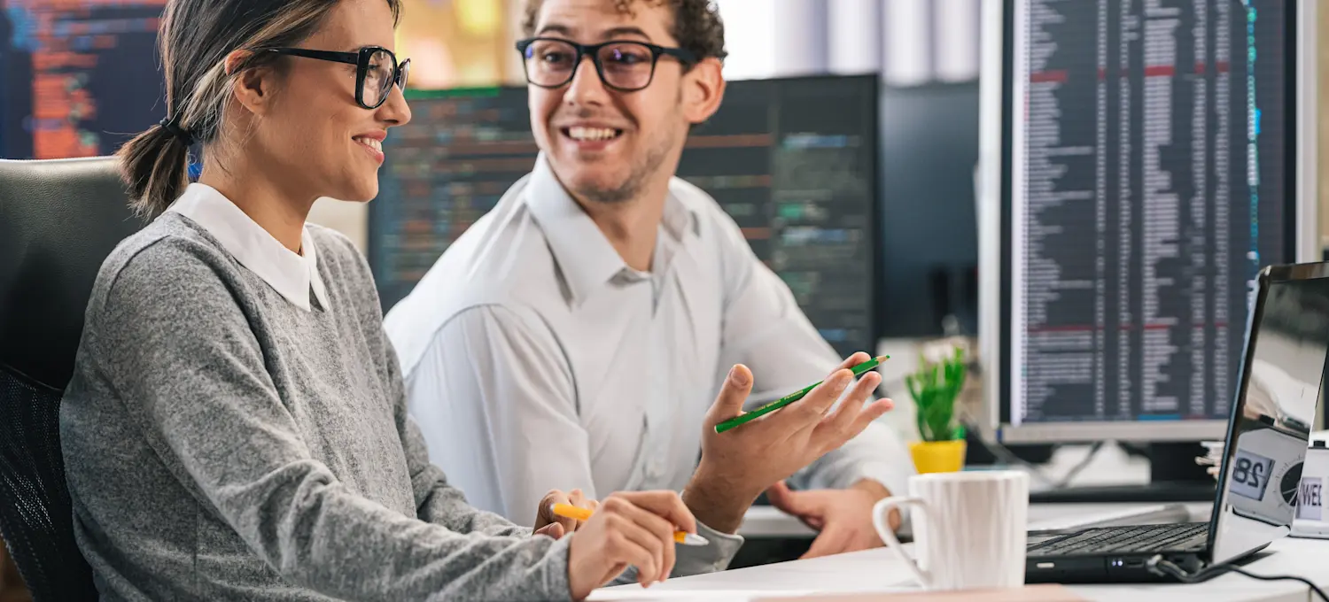 [Featured Image]: Software developers in a professional workspace discussing Agile versus Waterfall methodologies.
