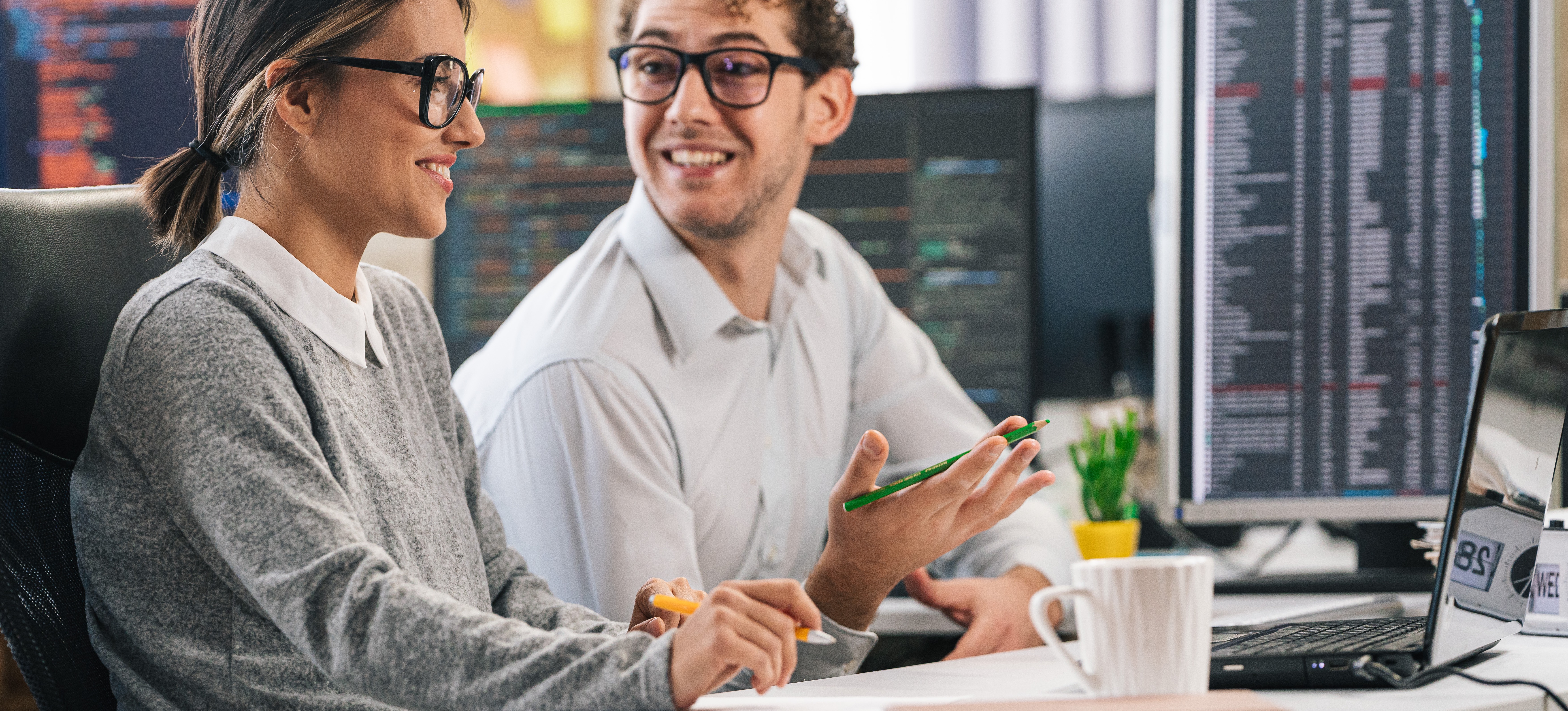 [Featured Image]: Software developers in a professional workspace discussing Agile versus Waterfall methodologies.
