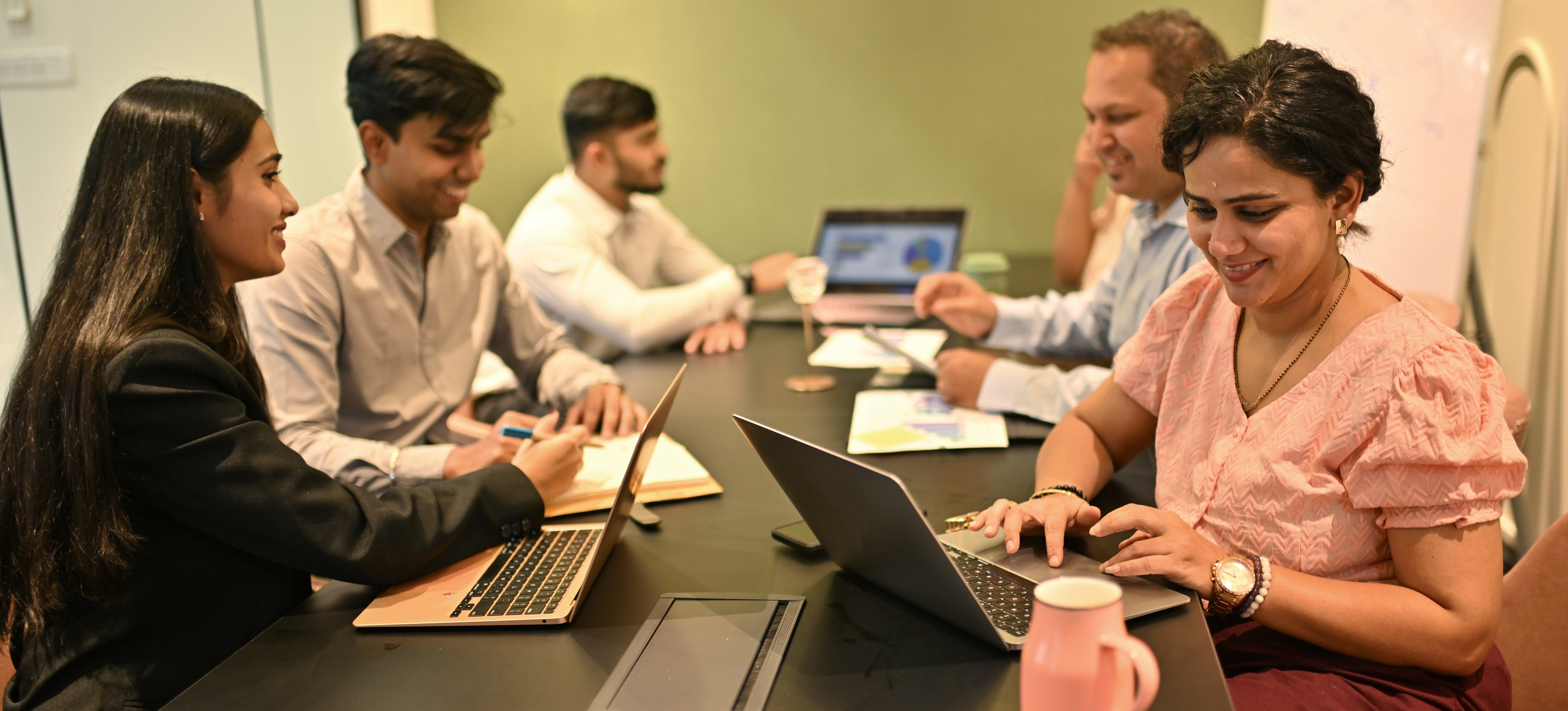 [Featured Image] A project manager helps to lead a team through a discussion about CAPM versus PMP.
