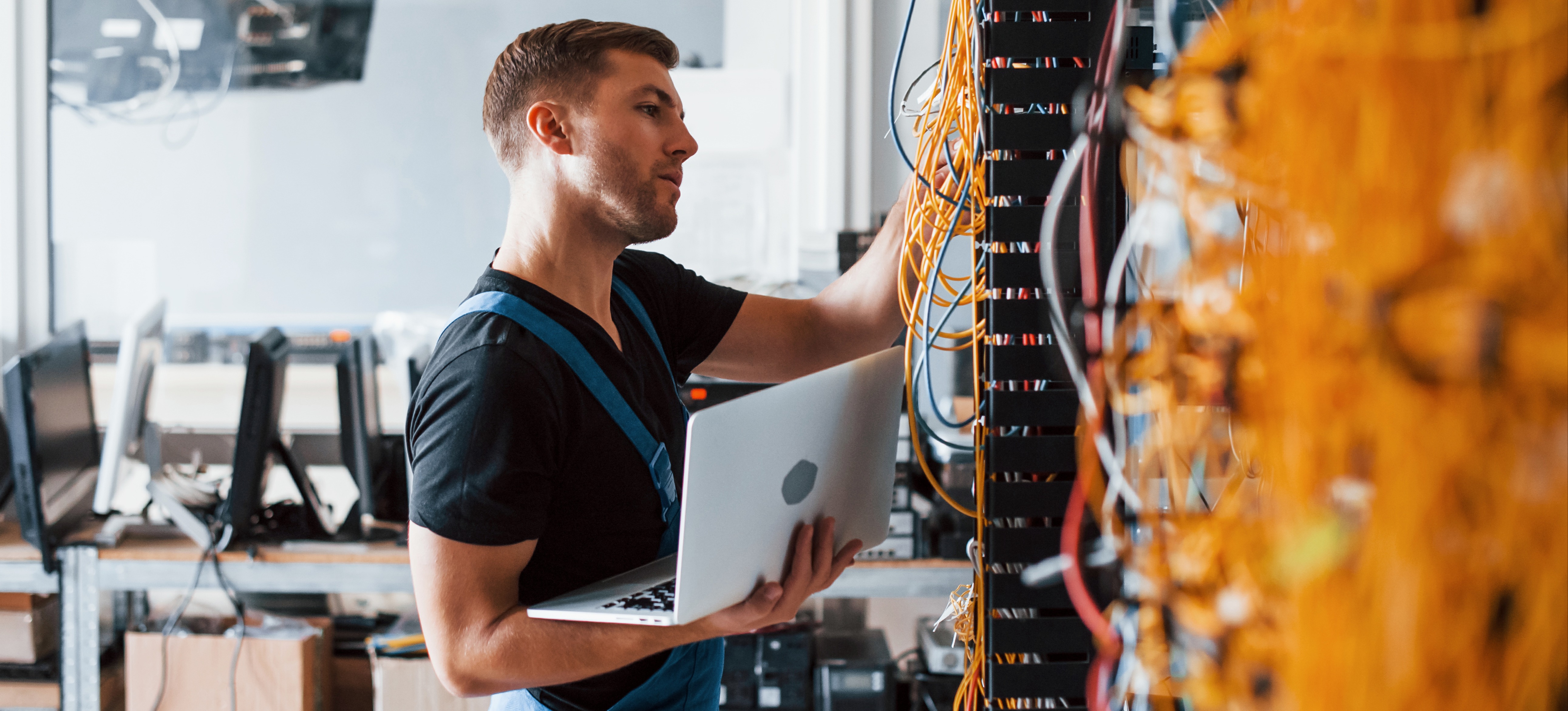 [Featured image] A network engineer inspects equipment used for data communication and data transfer.
