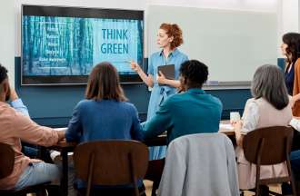 [Featured image] A marketing manager presents a new brand campaign to stakeholders in a conference room.