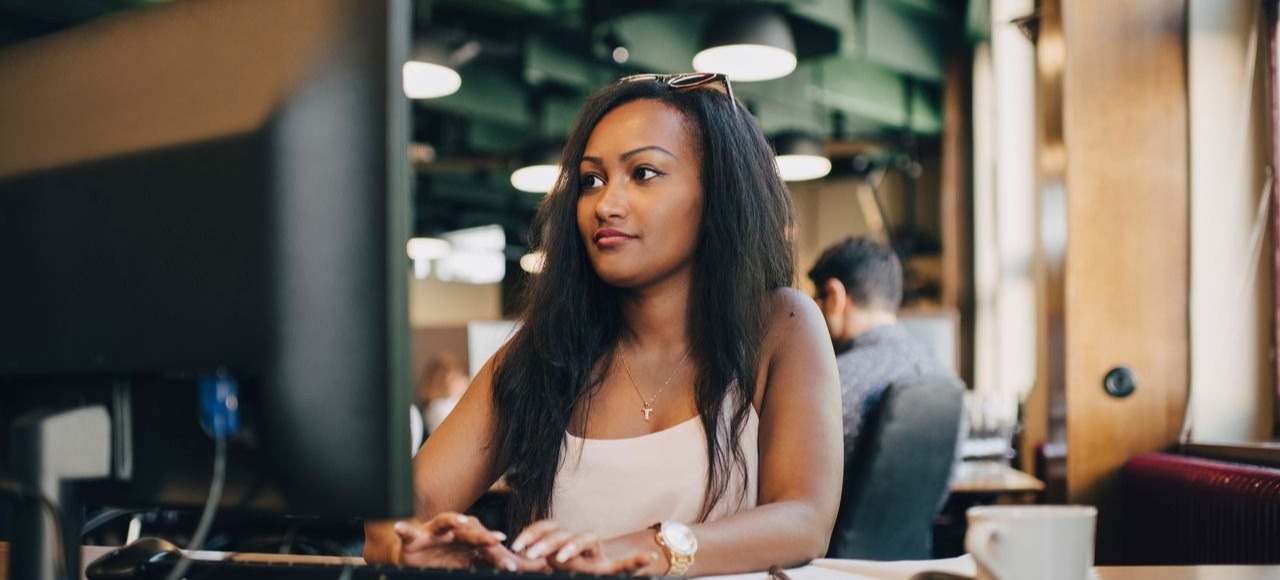 [Featured image] An app developer is working on their laptop in the office. 