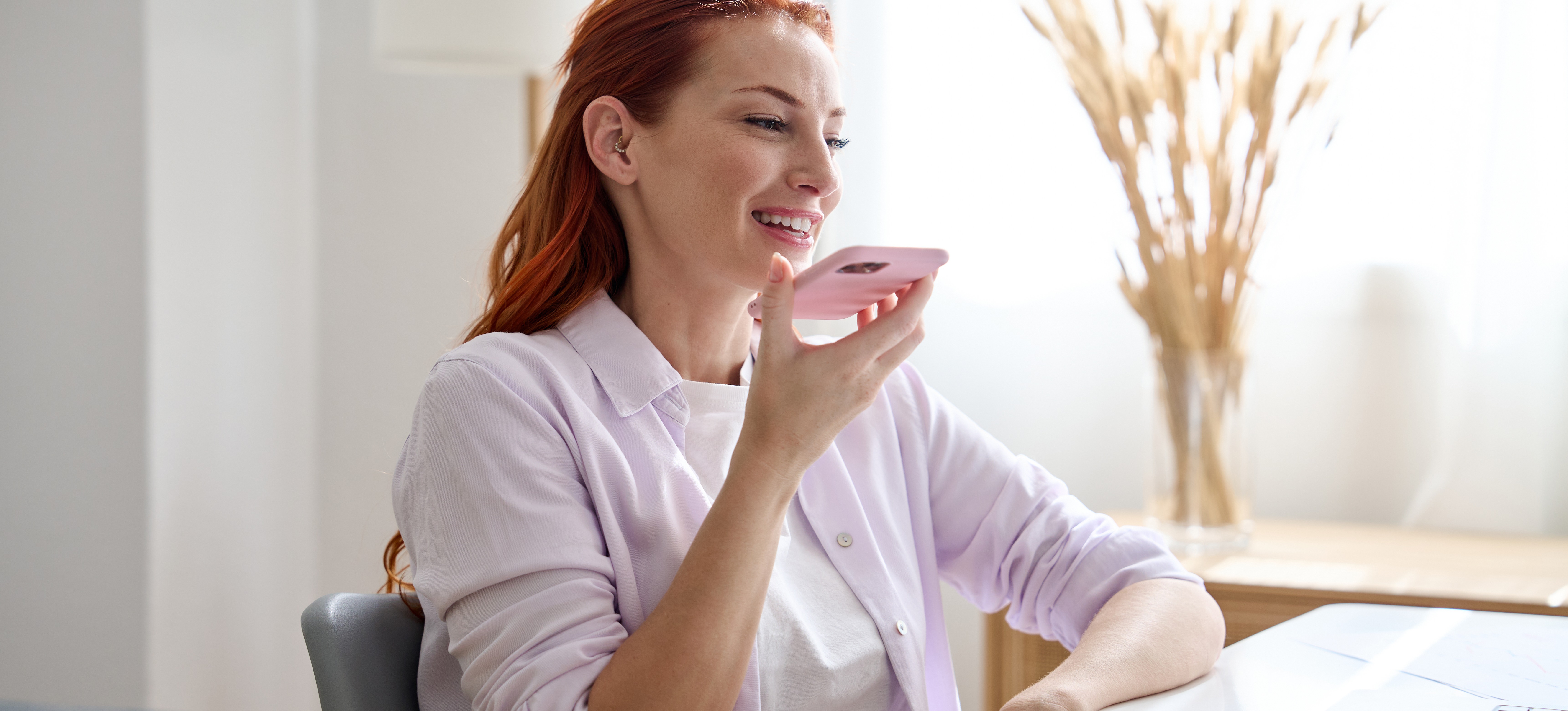 [Featured Image]: A woman speaks into her phone as she practices how to use NotebookLM effectively.