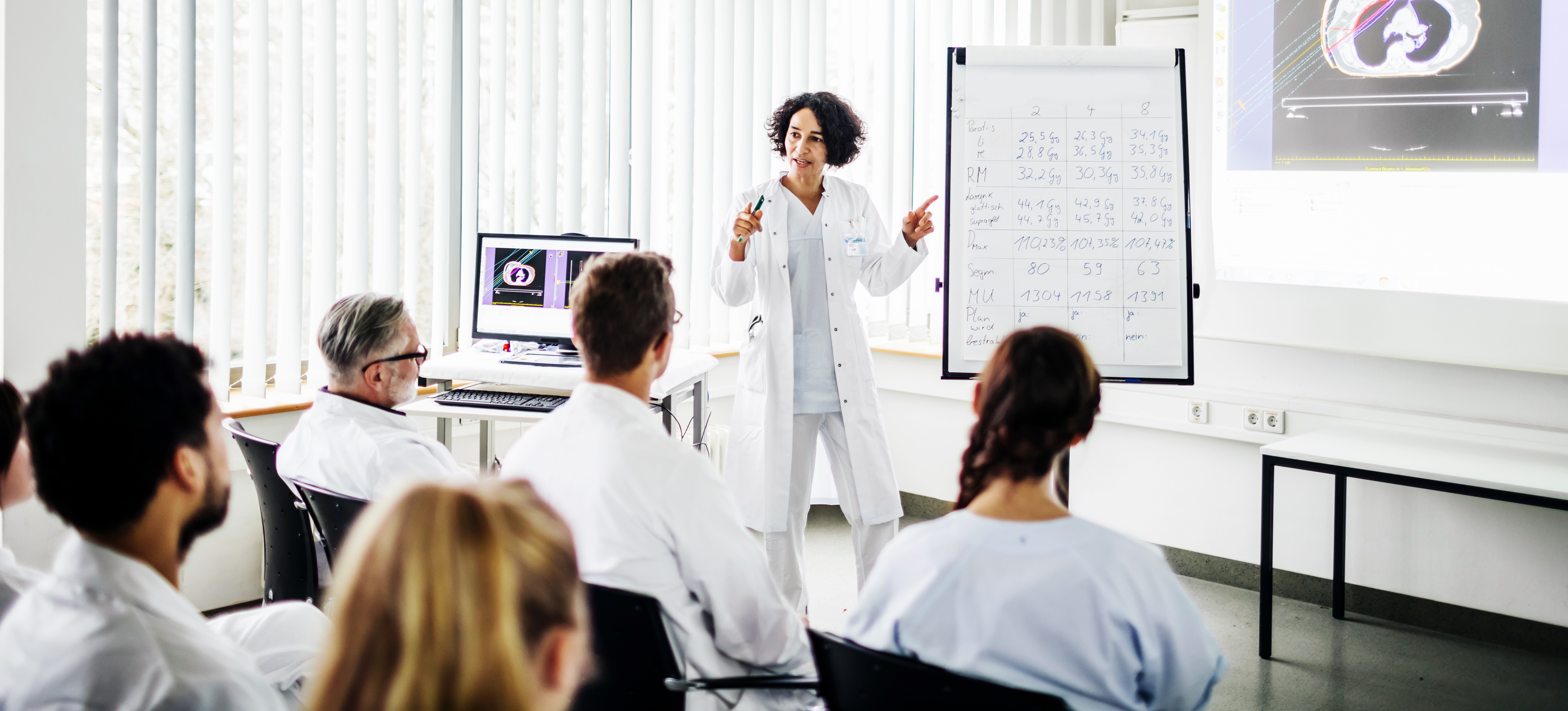 [Featured Image] An instructor explains to medical professionals how they will use augmented reality in health care as part of their job.