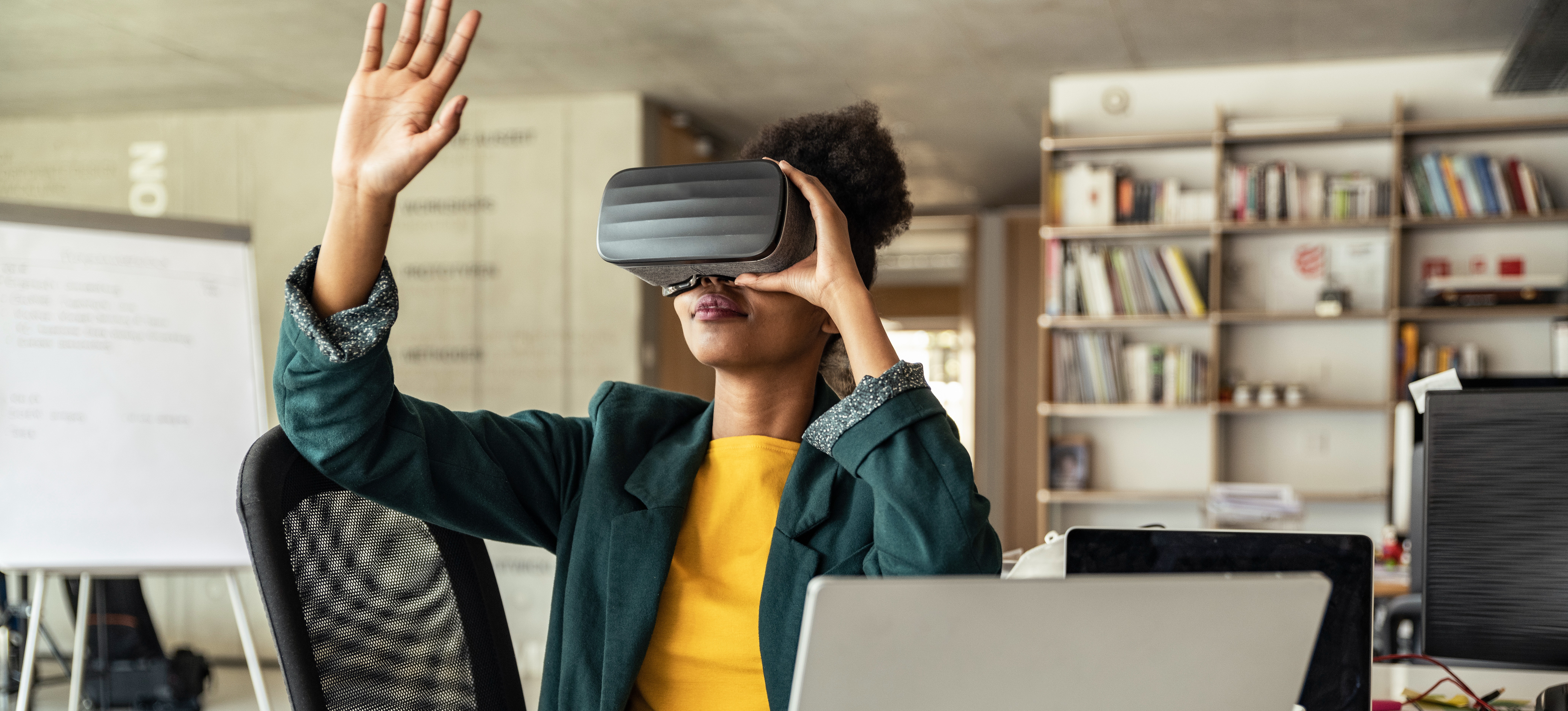 [Featured Image] A young professional takes advantage of one of their company’s virtual reality applications for training and professional development. 
