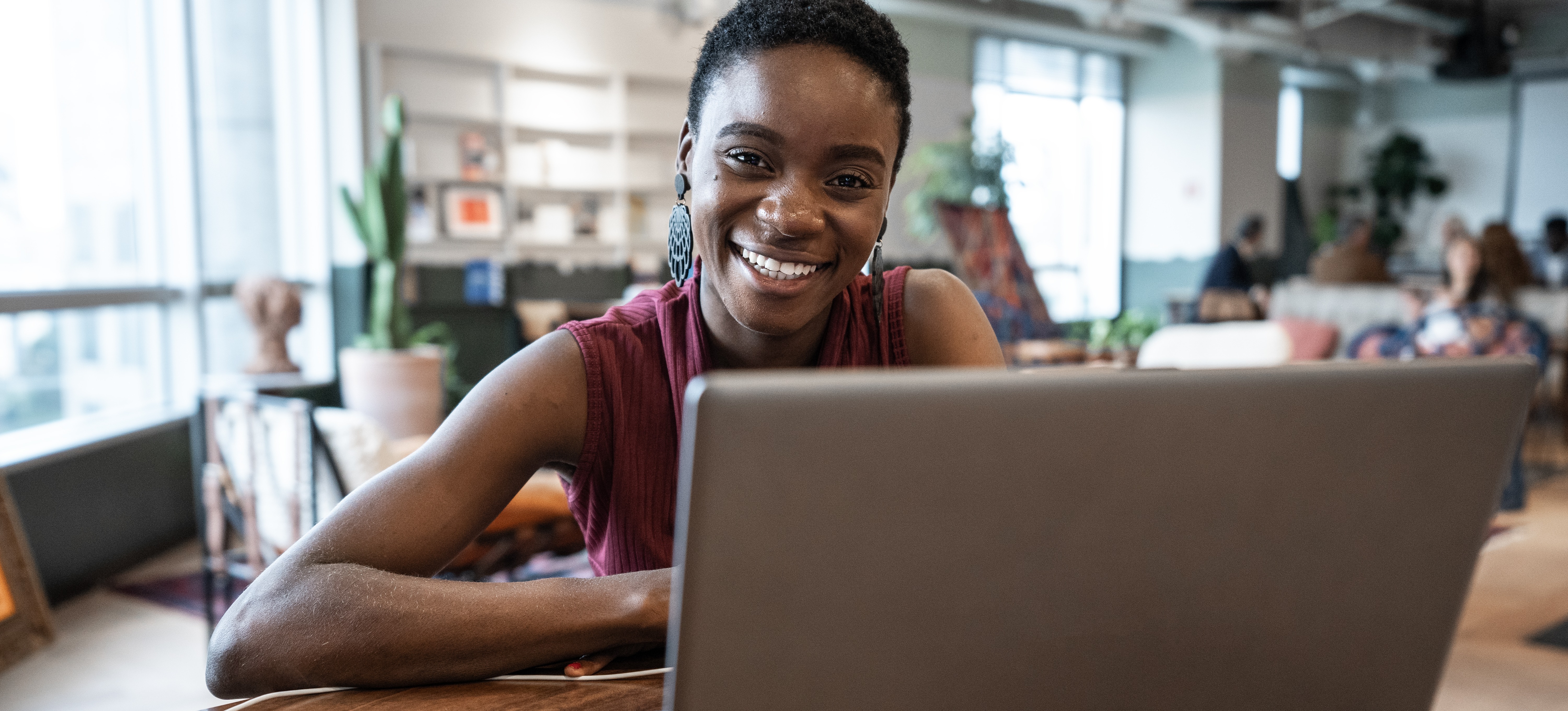 [Feature Image] A college student smiles as they research whether their school offers college credit for work experience as they plan their educational journey toward an advanced degree.
