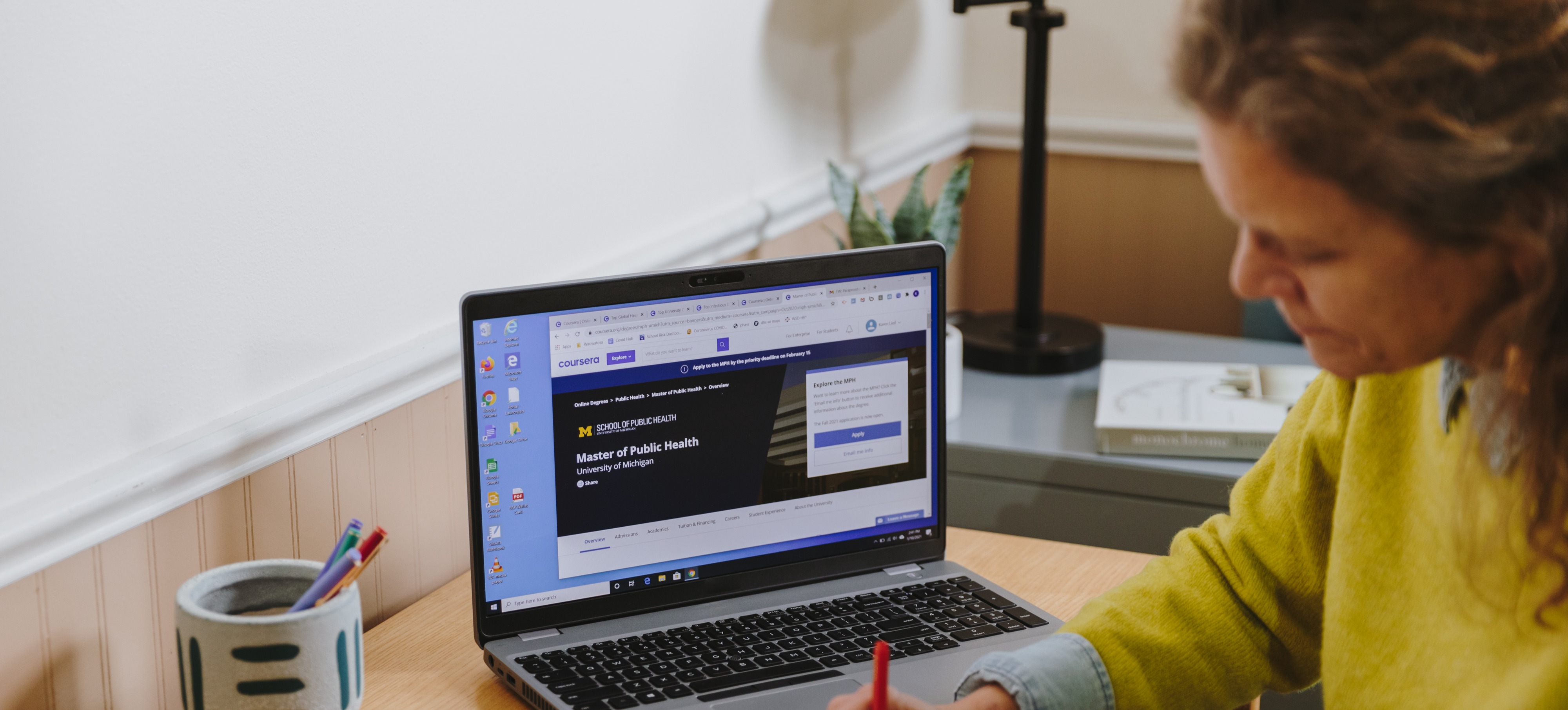 [Featured image] A resource manager takes notes in front of a laptop computer.