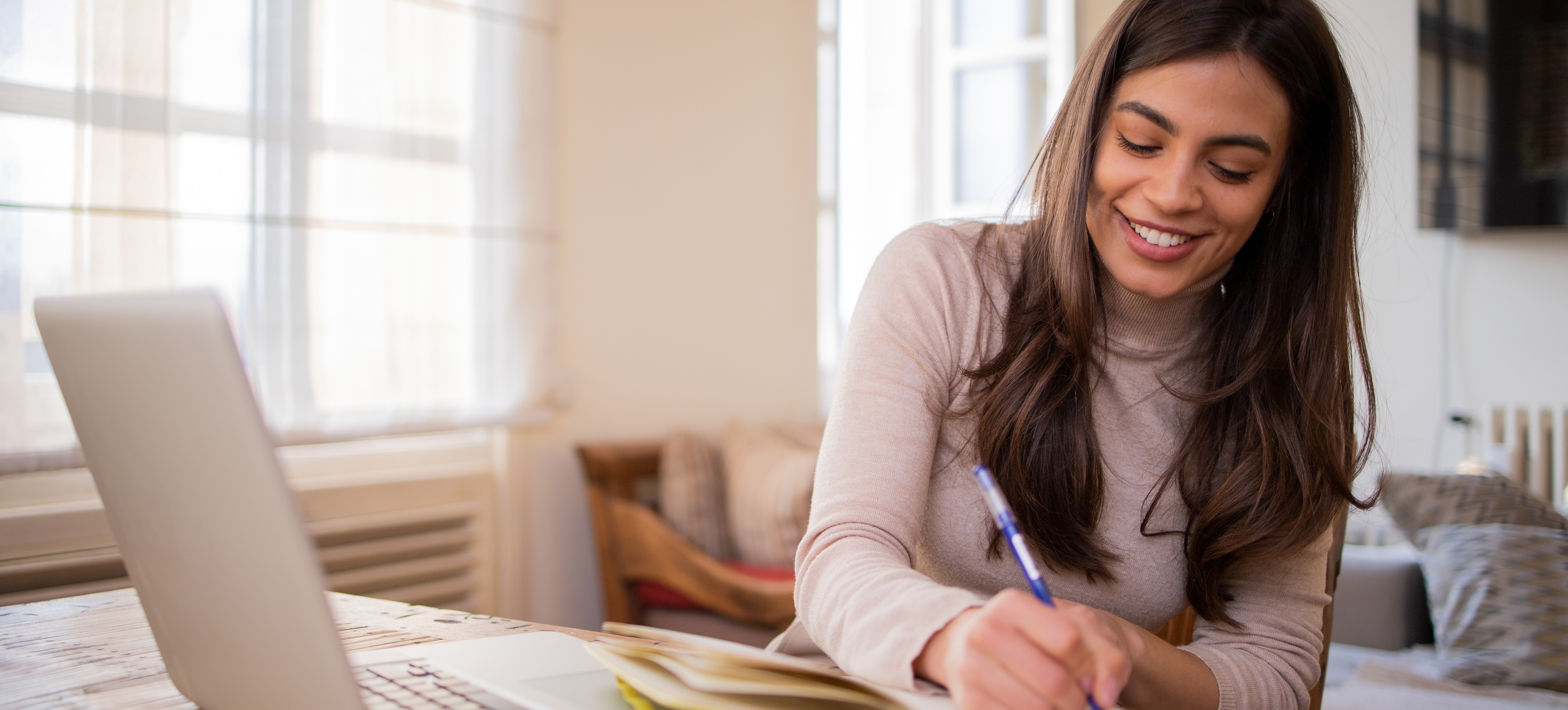 [Featured Image] A person wearing a turtleneck uses the Pomodoro study method while taking notes and listening to a lecture on their laptop.
