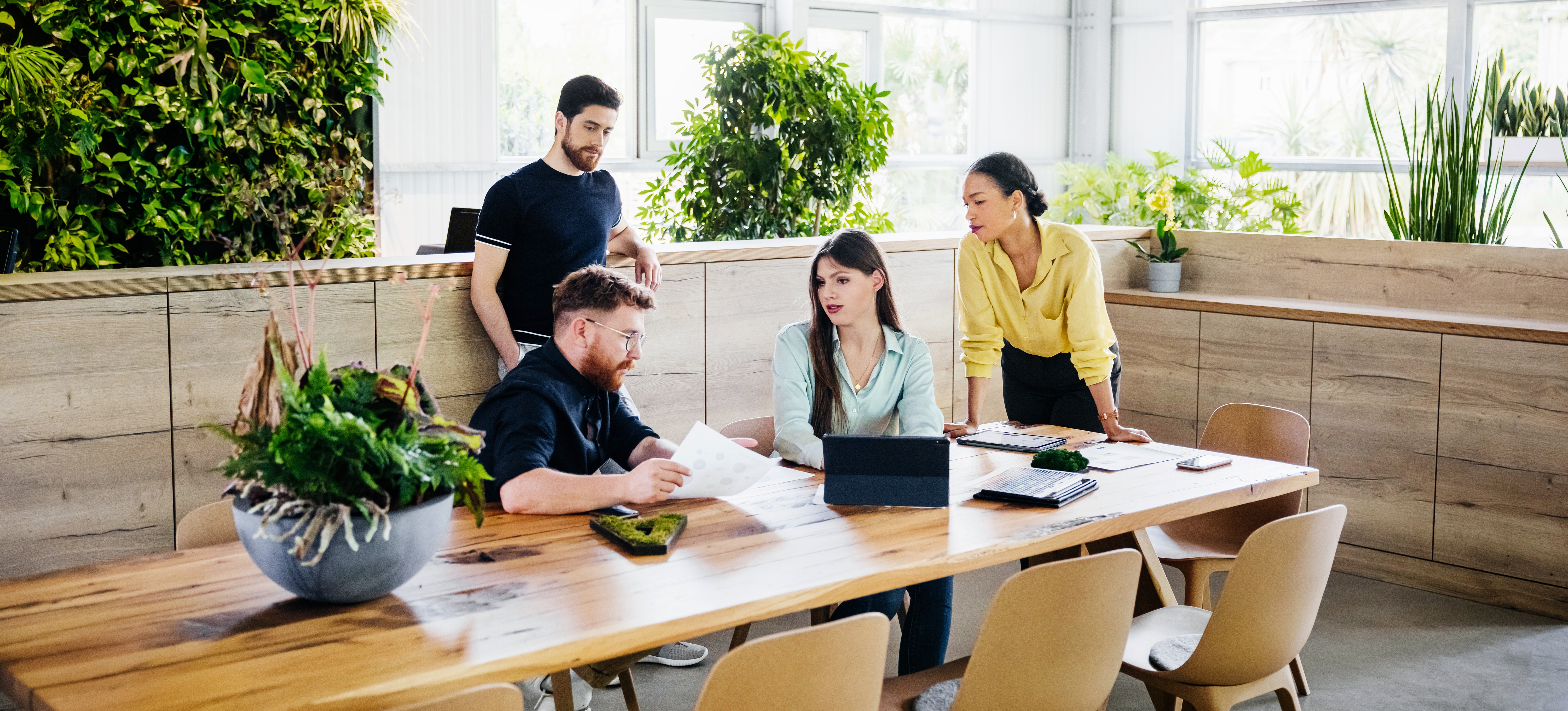 [Featured image] A product team outlines dependencies while making a project plan in a brightly lit conference room filled with plants.