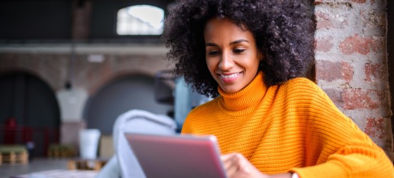 [Featured Image] An aspiring program manager confirms the difference between project managers and program managers on a tablet.