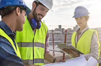 [Featured image] A civil engineer consults with a construction manager at a job site.