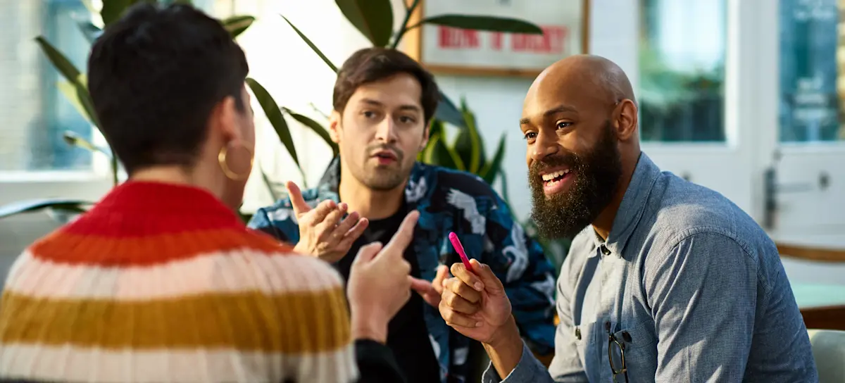[Featured image] Diverse colleagues discussing what is the best AI image generator in a team meeting.