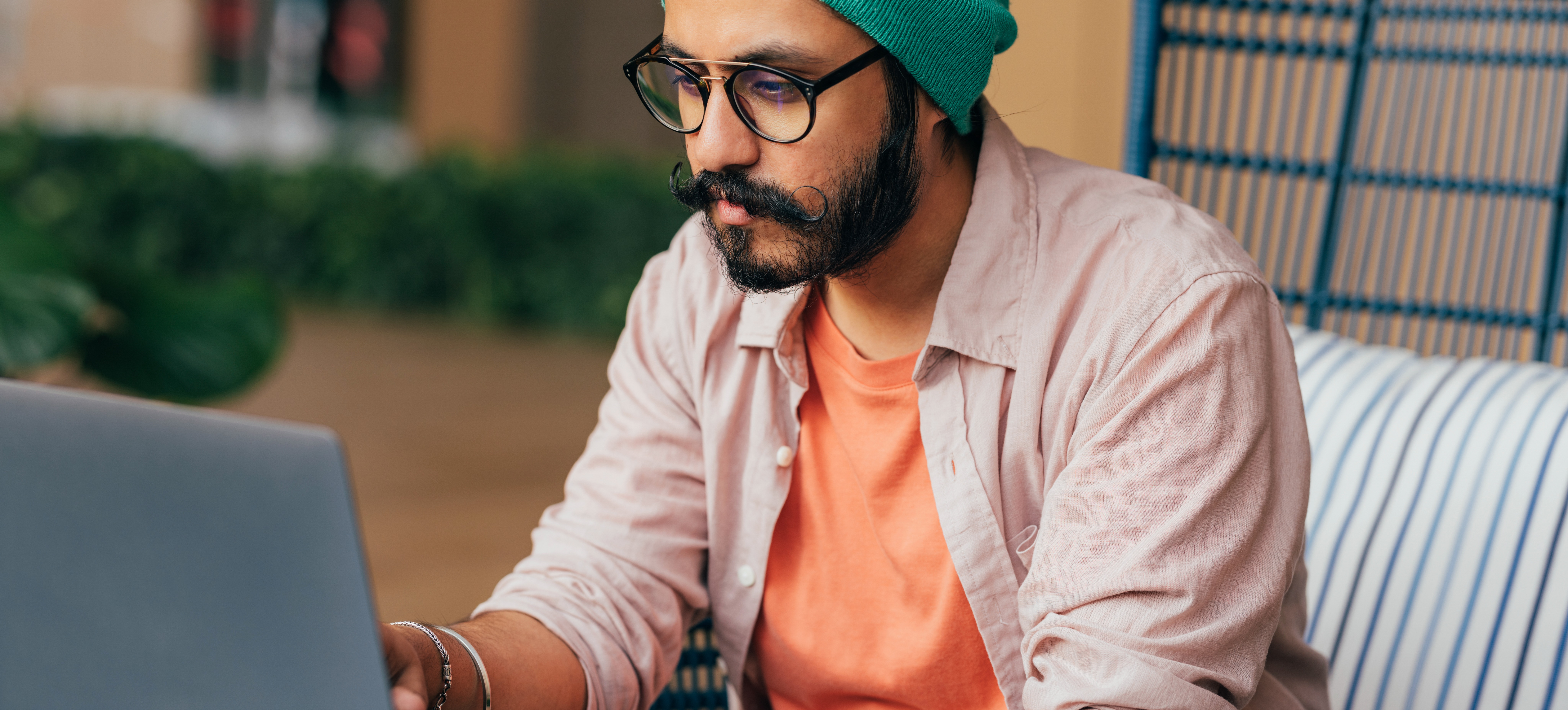 [Featured Image] An algorithm engineer sits outside the office and works on a laptop.  