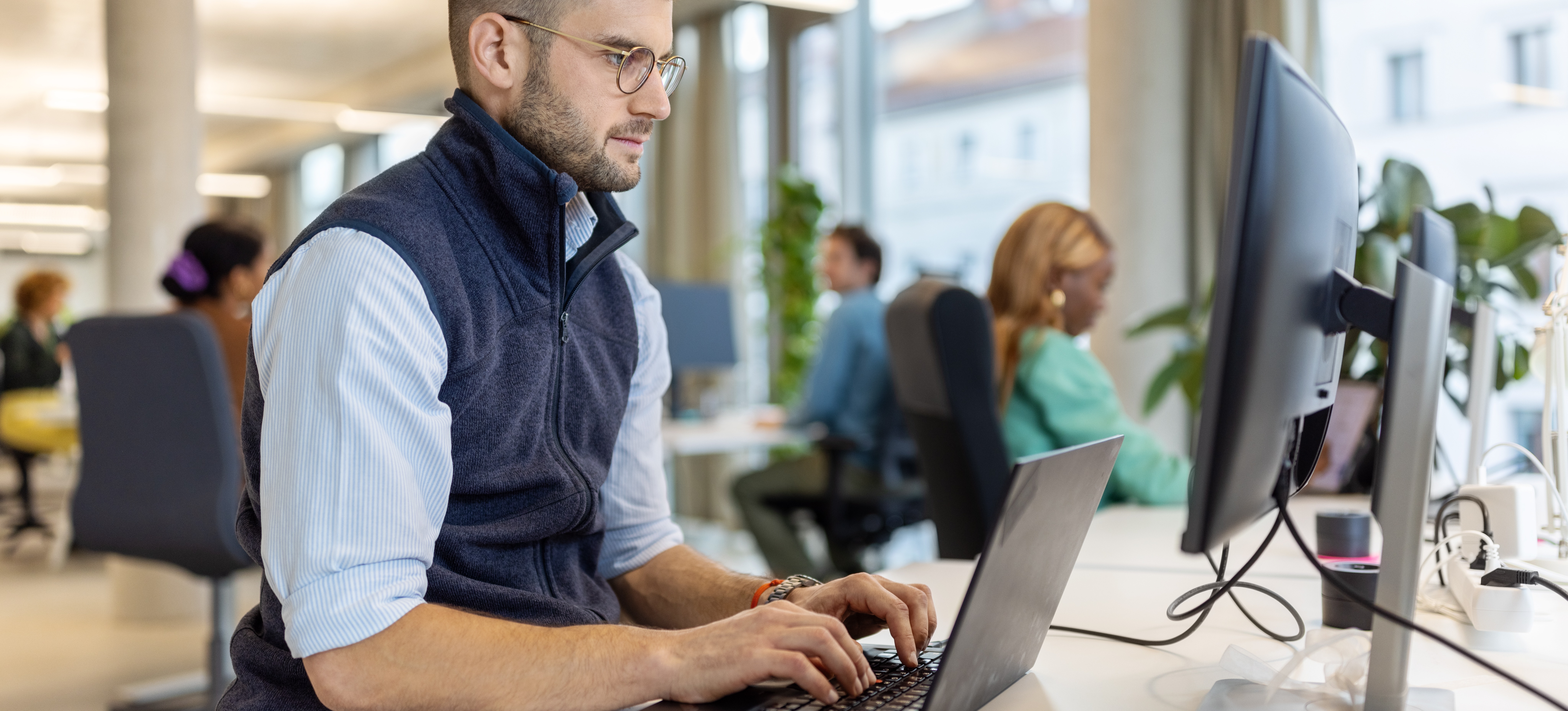 [Featured Image] An AWS Certified Developer Associate is working on a computer in an office.
