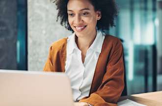 [Featured Image] A woman uses Google Sheets MATCH on her office computer.