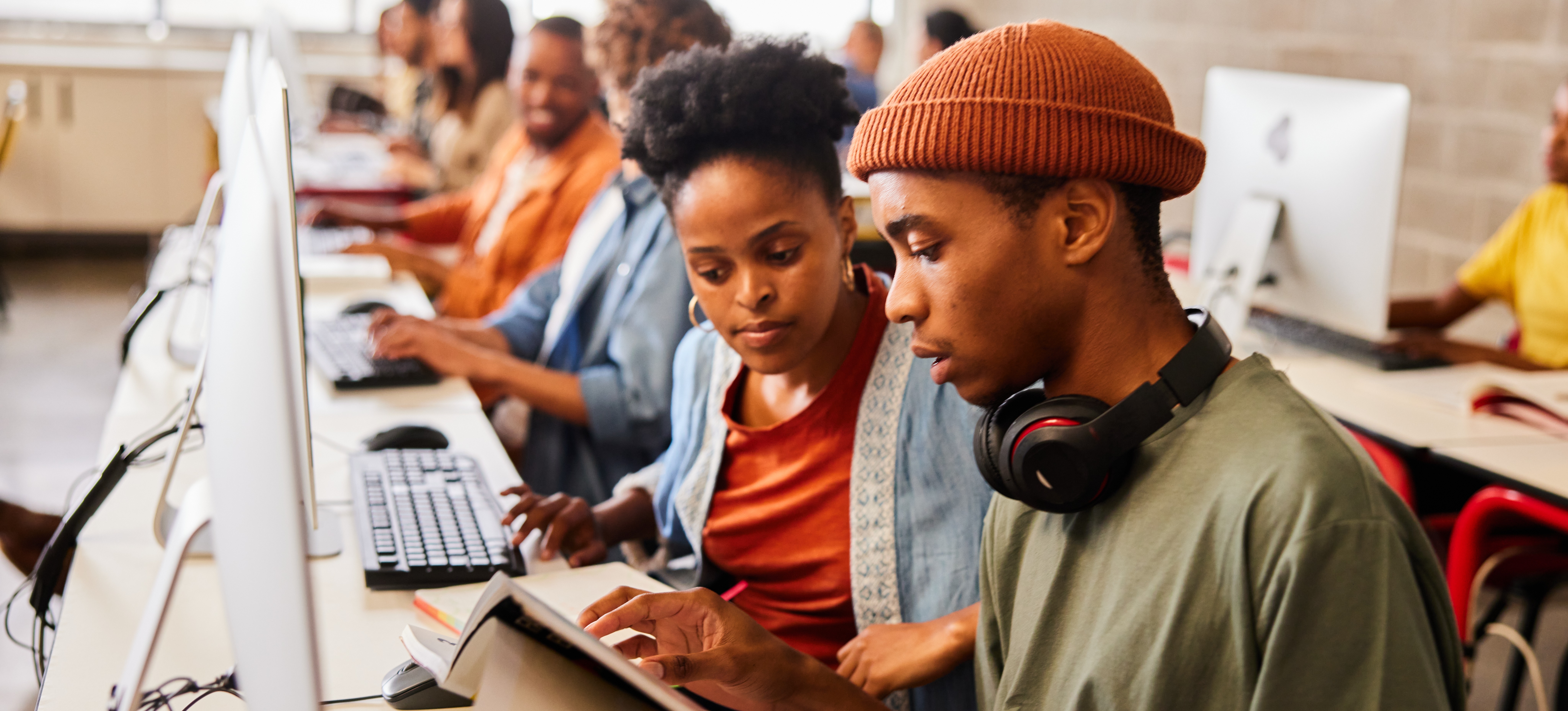 [Featured Image]: Students reading a textbook in a computer class.