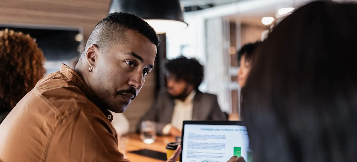 [Featured Image] Two business professionals are discussing content created by AI copywriting for their business project.
