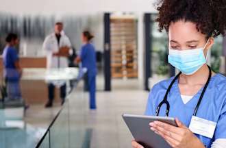 [Featured Image] A nurse is using a tablet.