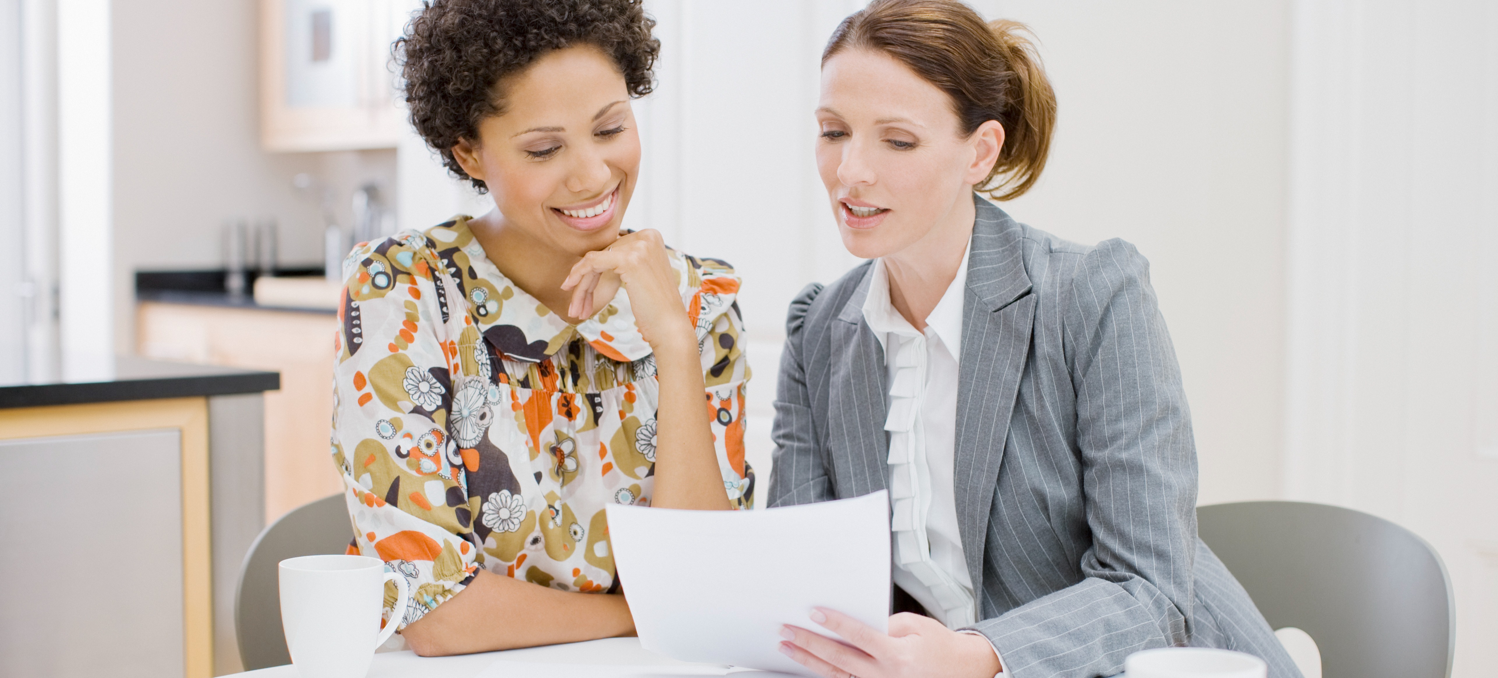 [Feature Image] An aspiring sales analyst meets with their mentor to discuss the process and benefits of getting a sales analyst certification.
