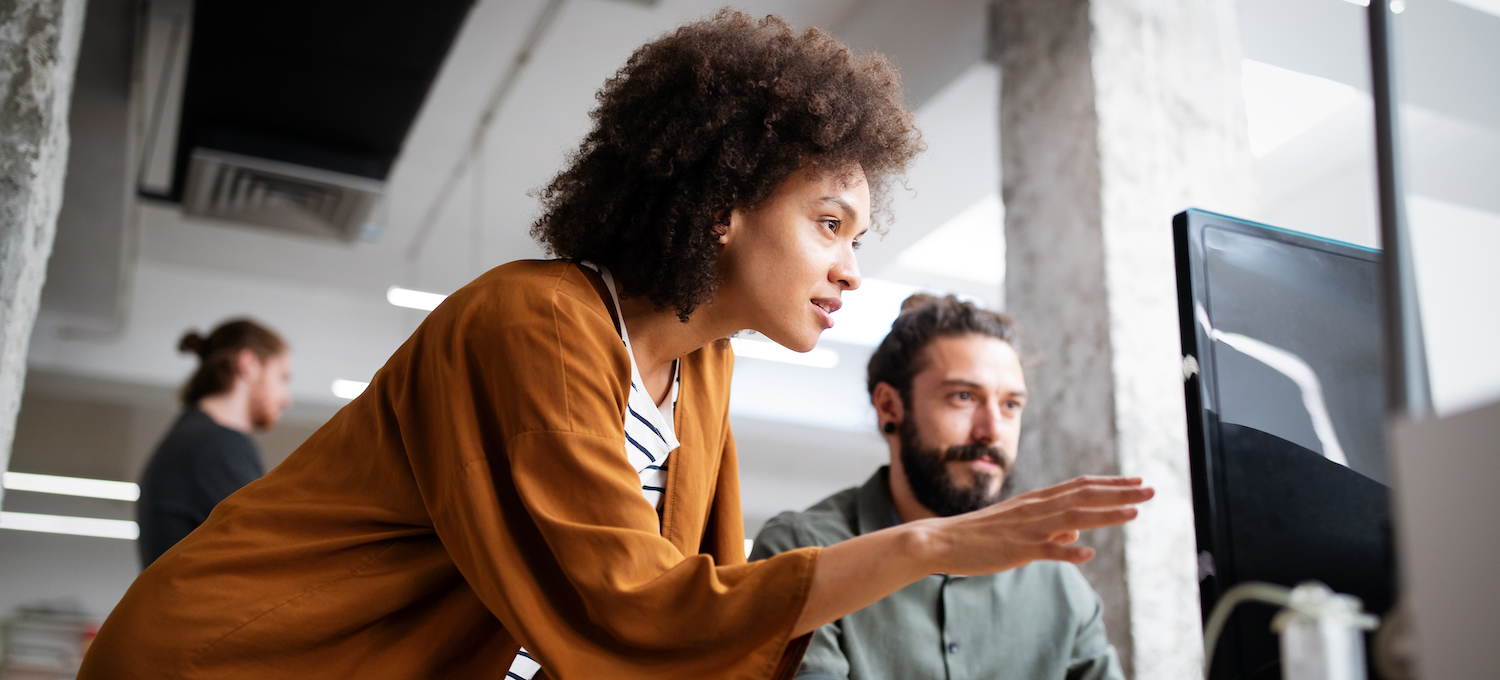 [Featured image] A person in DevOps points to their colleague's computer screen.