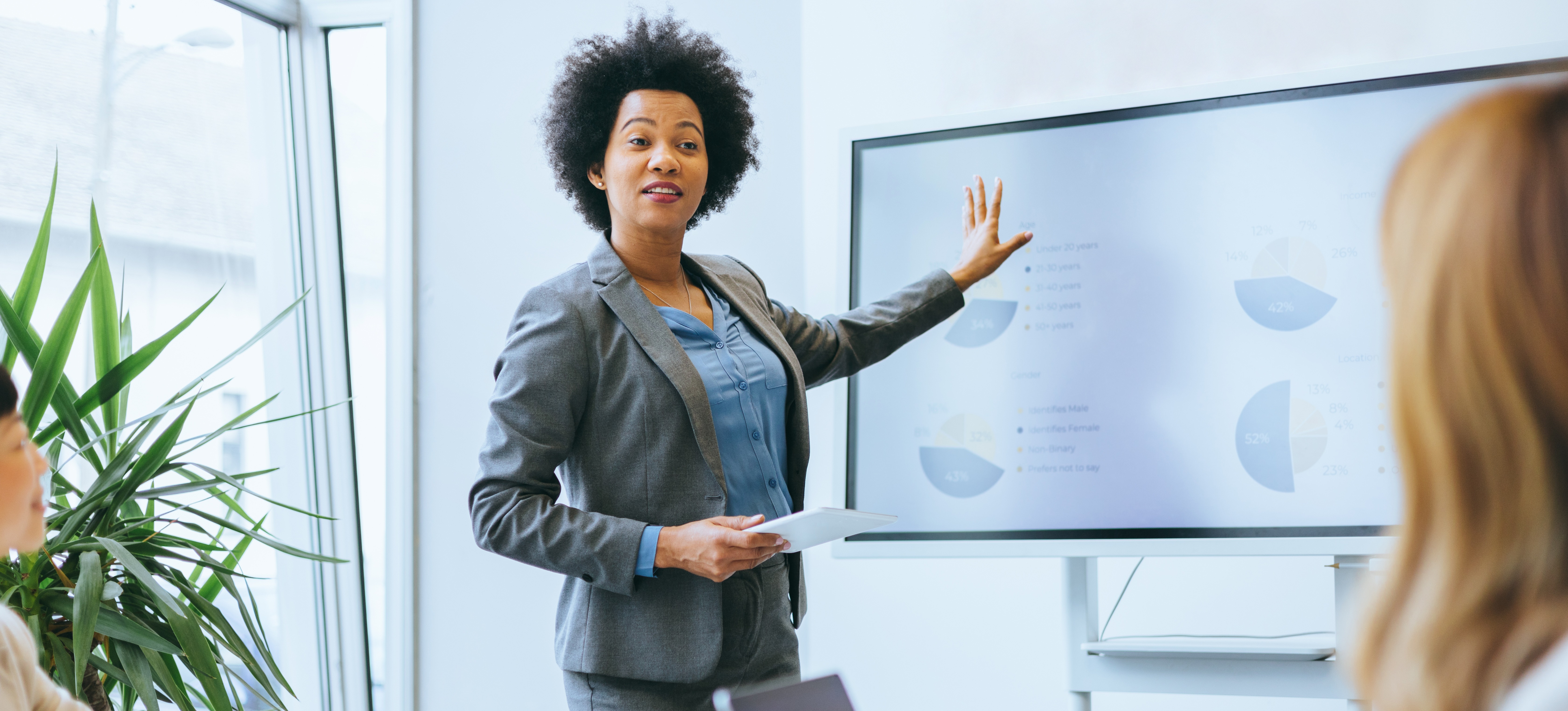 [Featured Image] An operations research analyst is in an office presenting her collected data to her colleagues.

