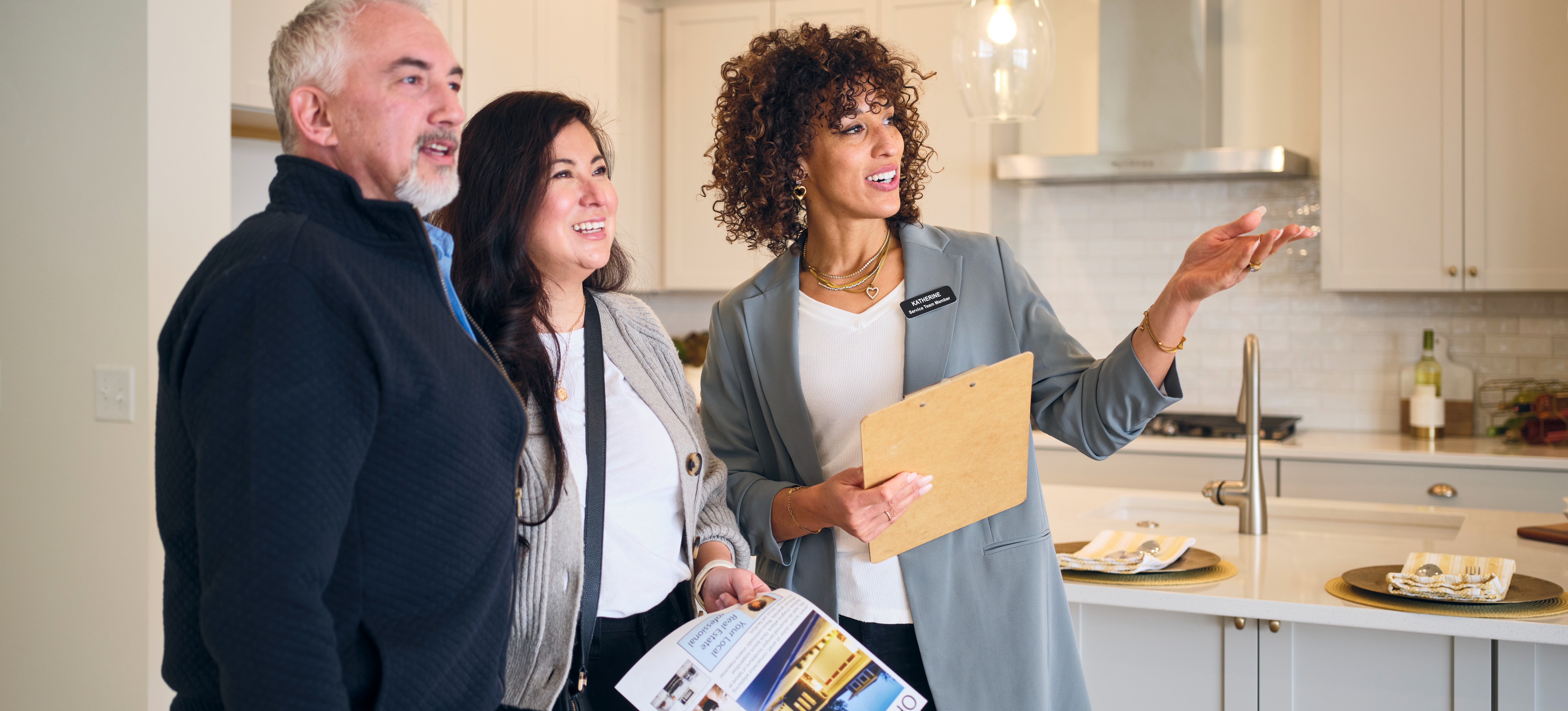 [Featured Text]: A real estate agent shows a home to prospective buyers who explored realtor vs. real estate agent before hiring someone.