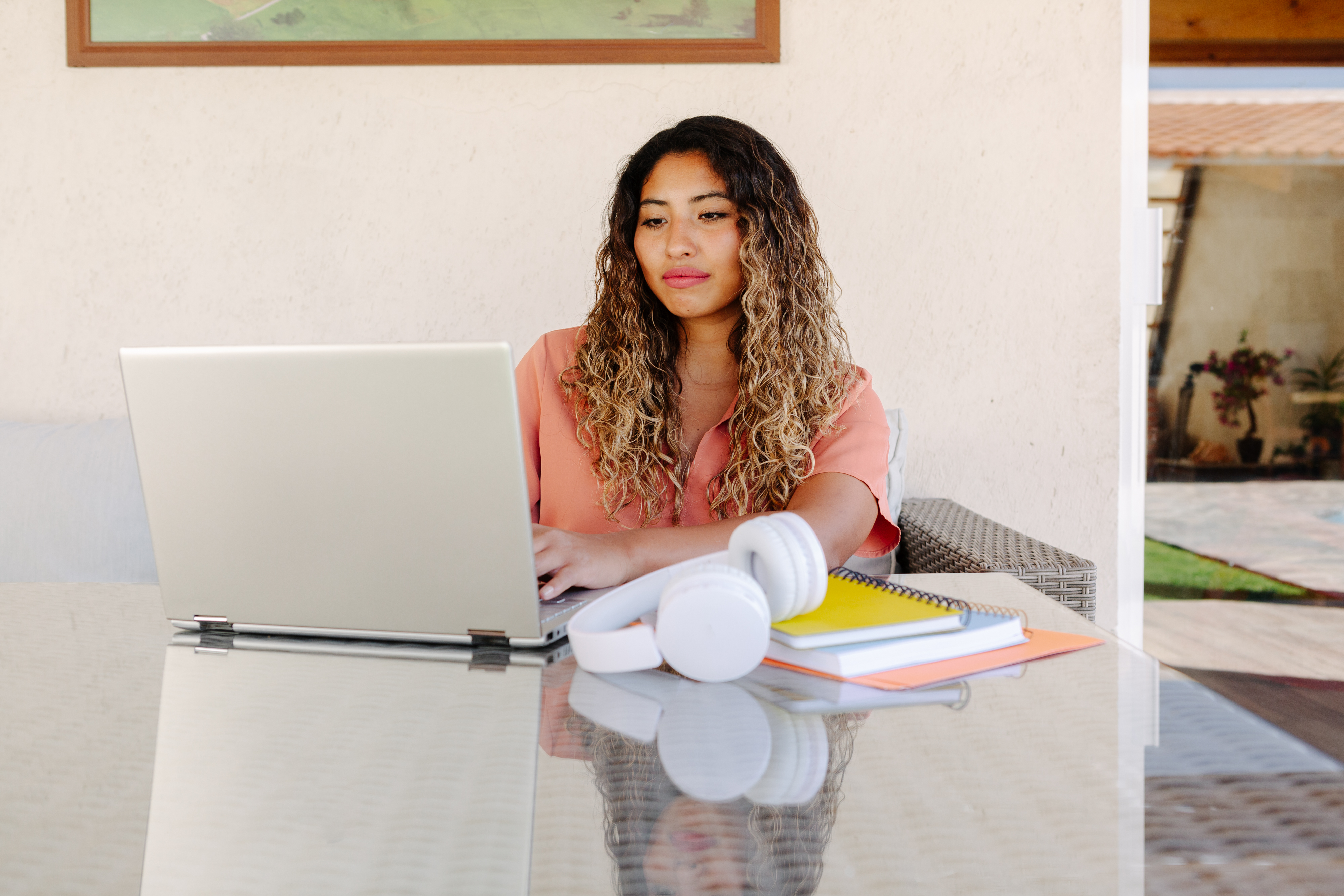 [Featured image] Woman sits at her desk taking notes on her laptop on how to set up a Shopify store to launch hers online.

