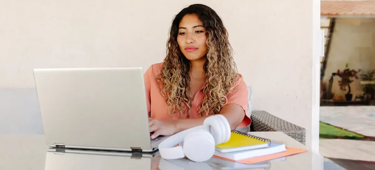 [Featured image] A small business owner sits at their desk, taking notes on a laptop on how to set up a Shopify store to launch theirs online.
