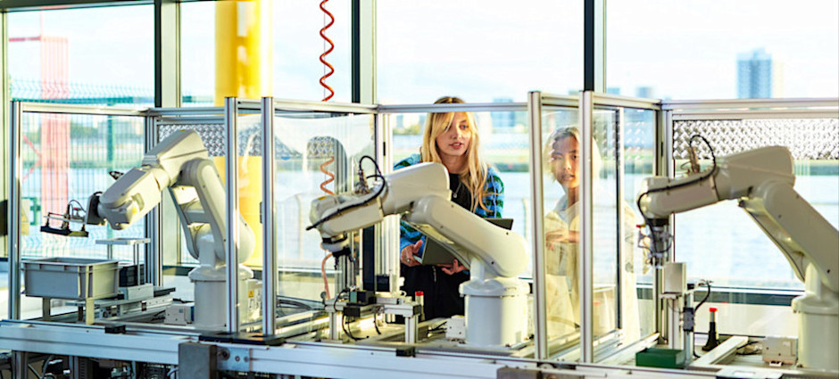 [Featured Image] Two engineers use few-shot learning to train a robotic device.
