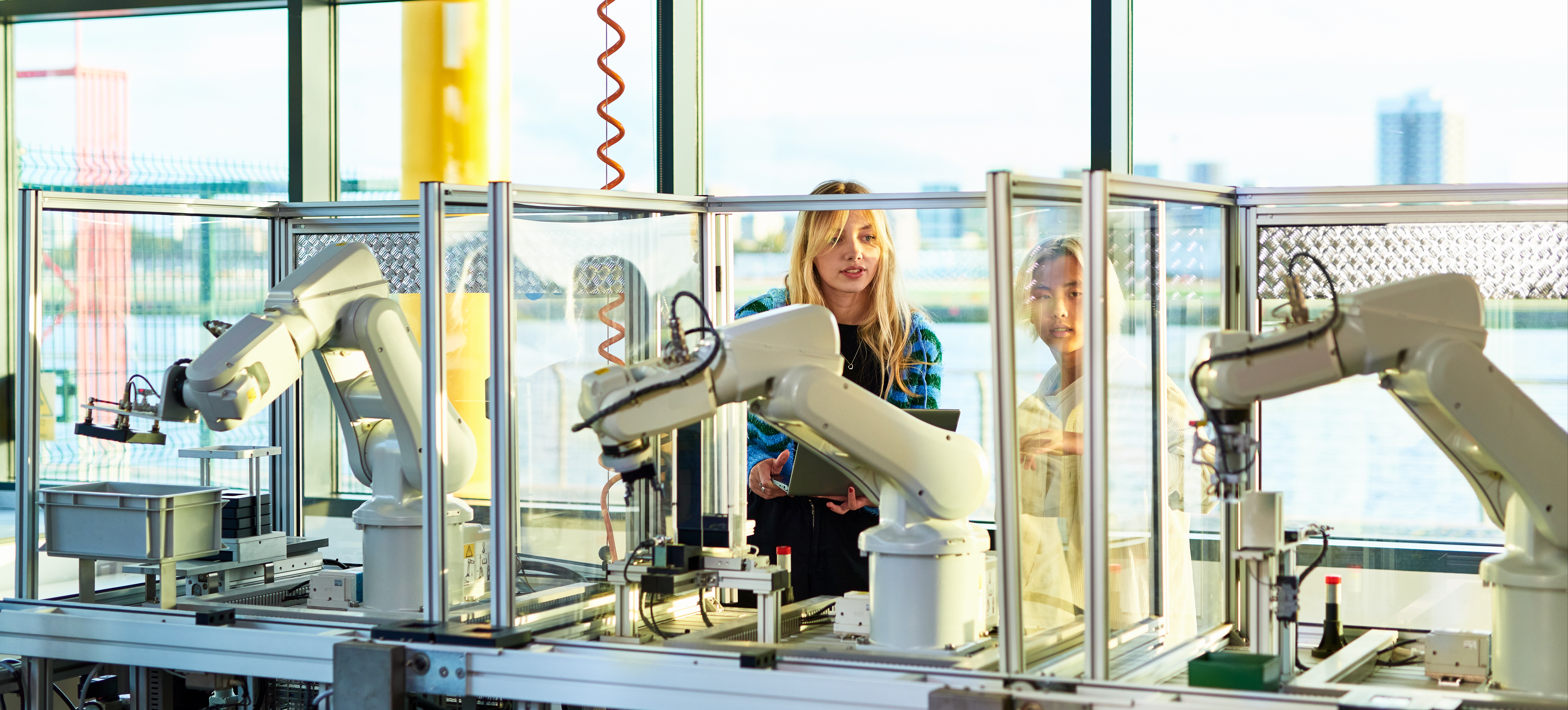 [Featured Image] Two engineers use few-shot learning to train a robotic device.
