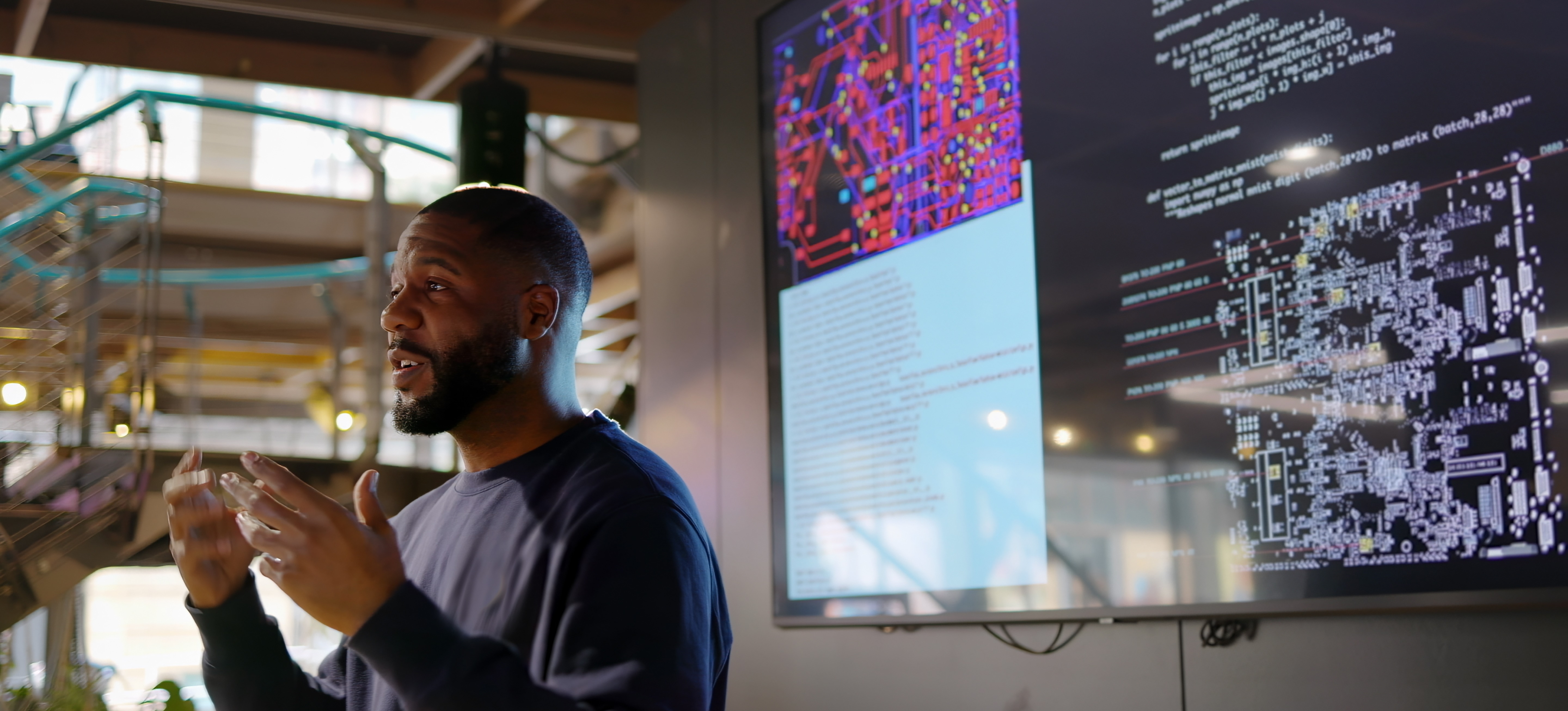 [Featured Image] A cybersecurity analyst stands before a large computer screen displaying complex code in a technical workspace, monitoring threats with an SIEM system.
