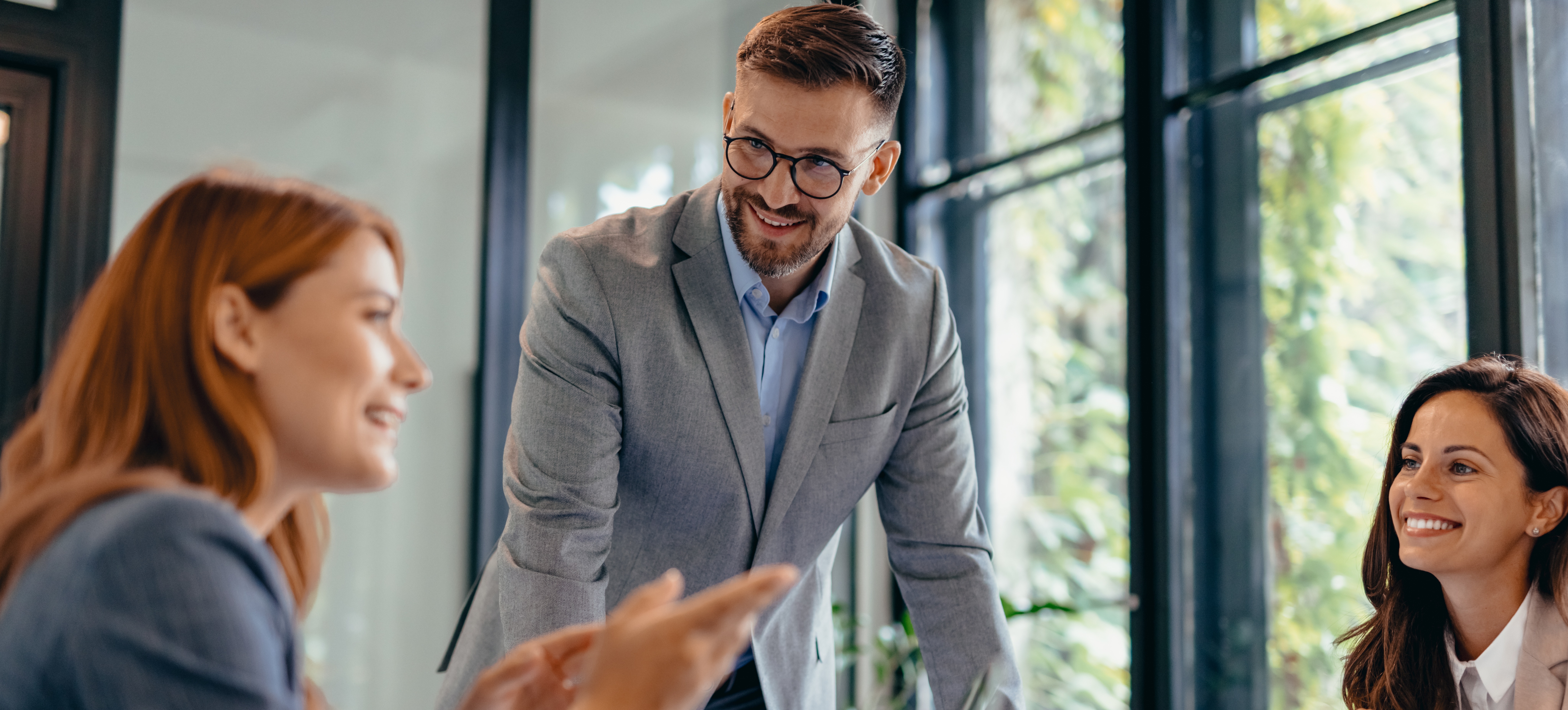 [Featured Image] A manager attentively listens during a meeting, fostering collaboration in a professional workspace.

