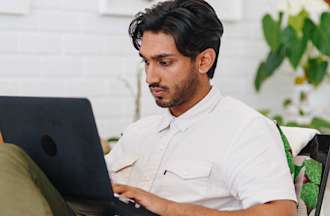 Featured image: A person wearing a white shirt looking at a laptop screen and typing.