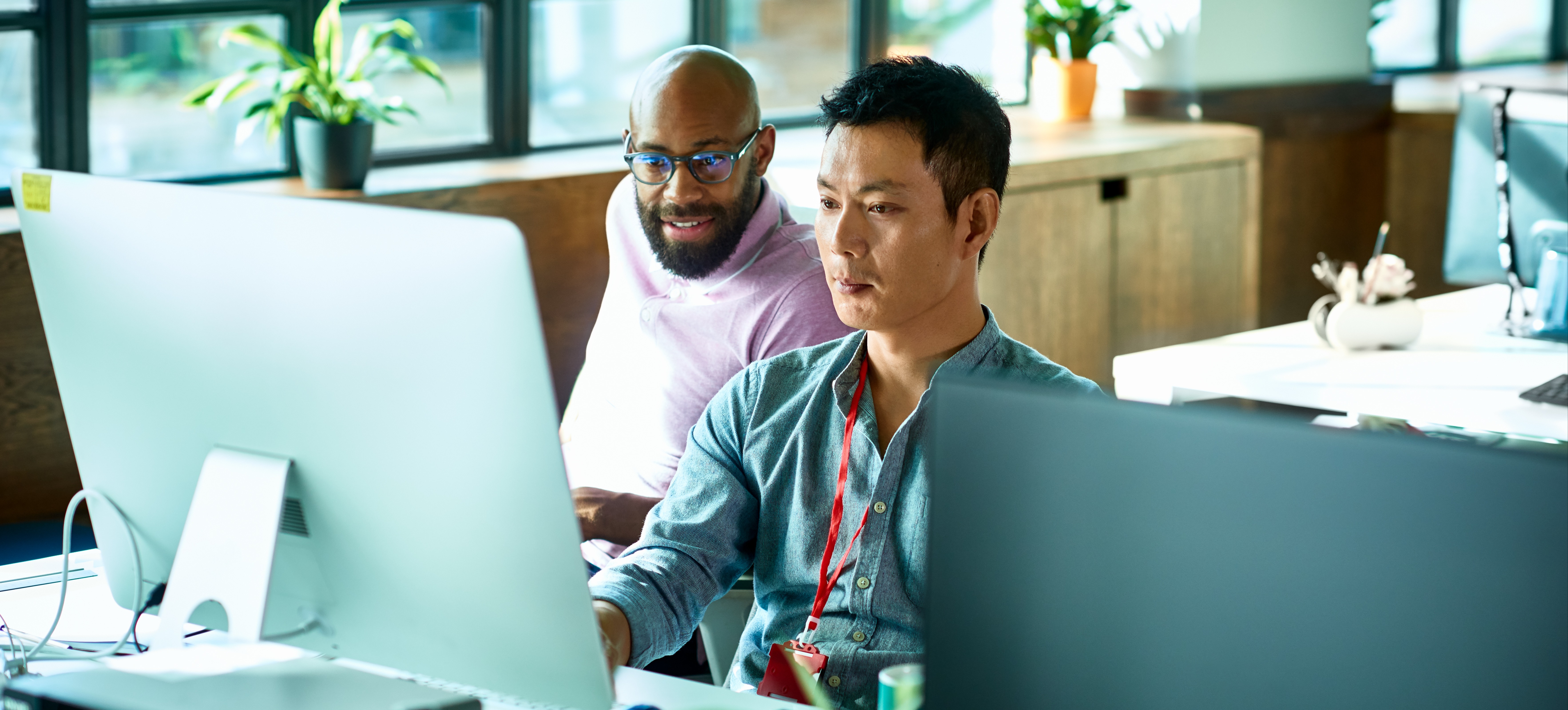 [Featured image] Two software developers performing white box testing on a desktop computer in an office.