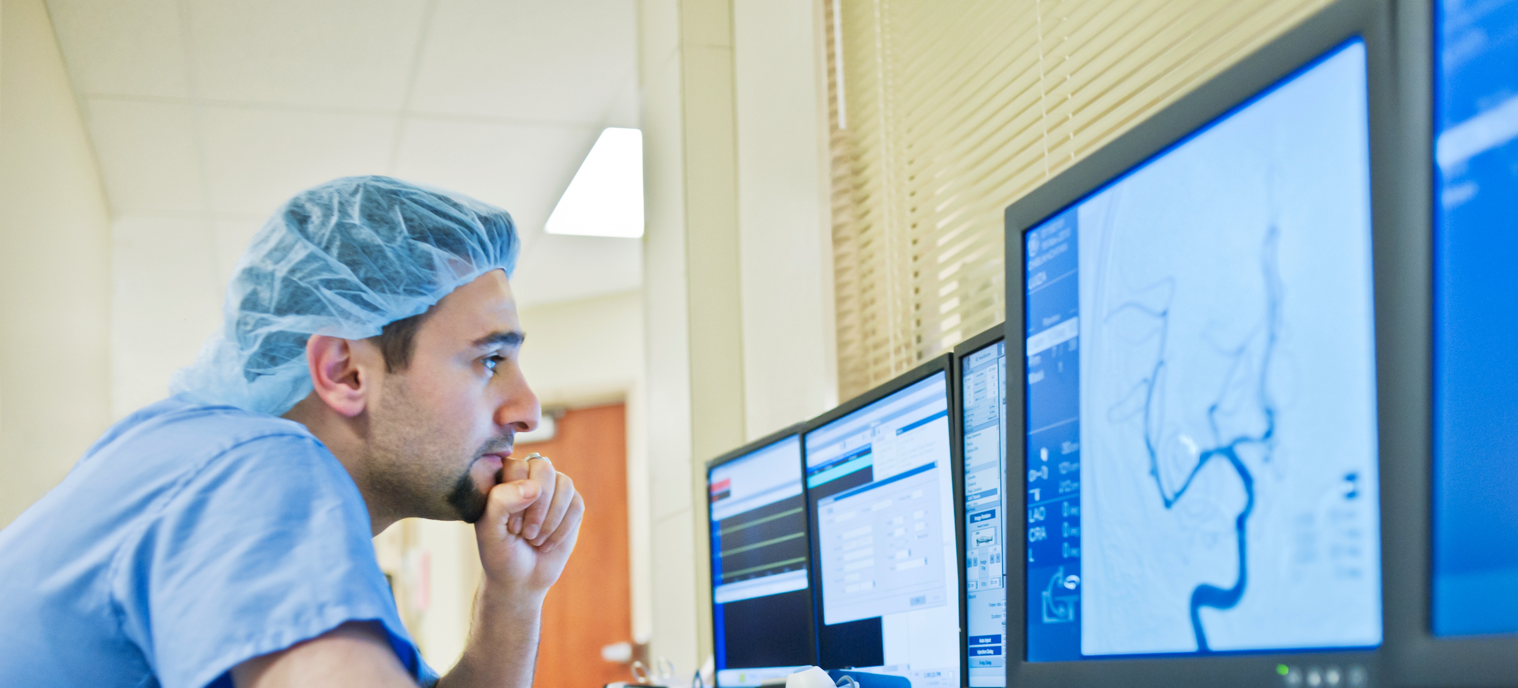 [Featured Image]:  A public health care worker, working at their desktop computer, is analyzing the charts of a patient.