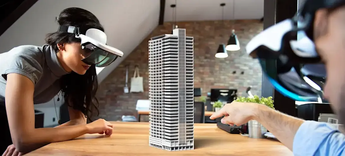 [Featured Image] Two architects are using AR skills to create a 3D prototype of a building project.

