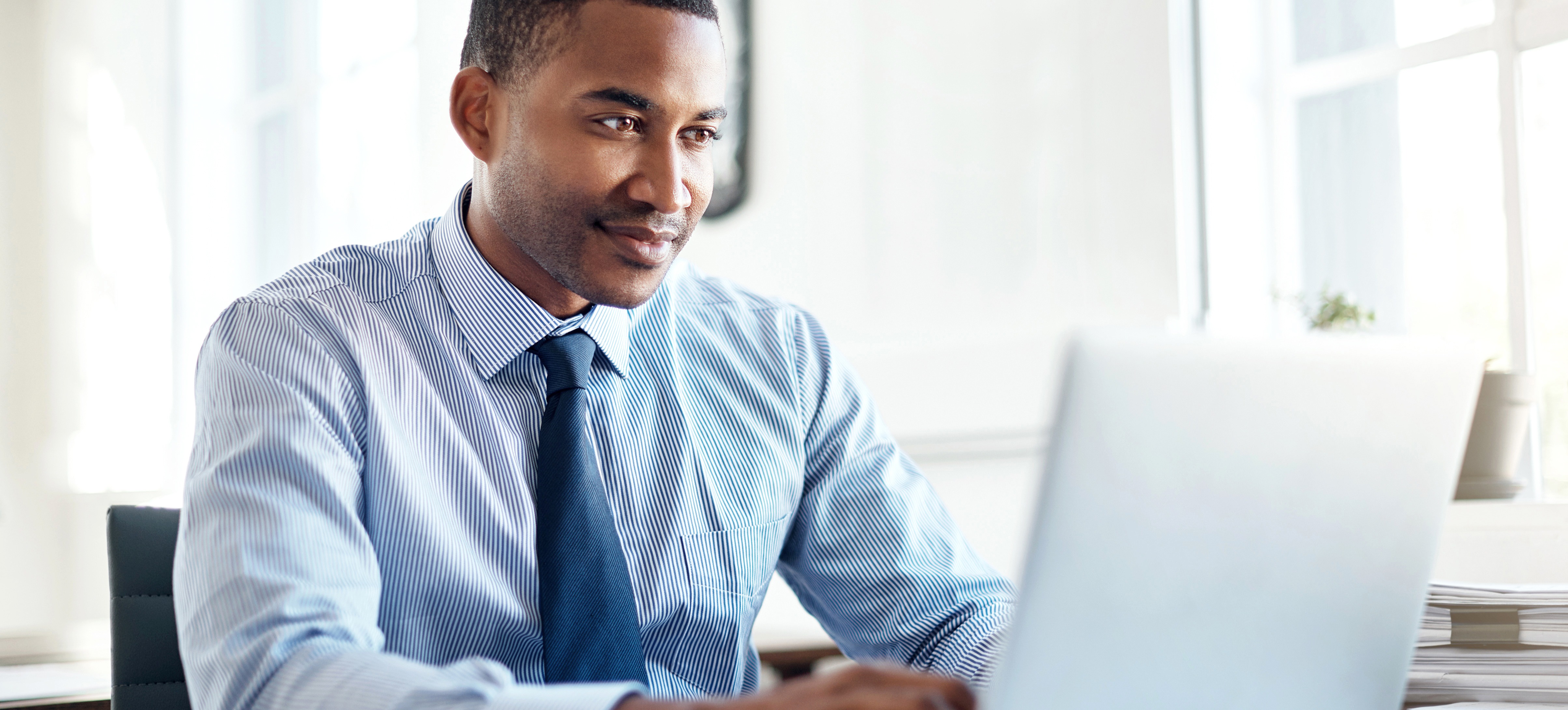 [Featured Image] A professional is working on their laptop and adds drop down menus to Google Sheets for a project. 