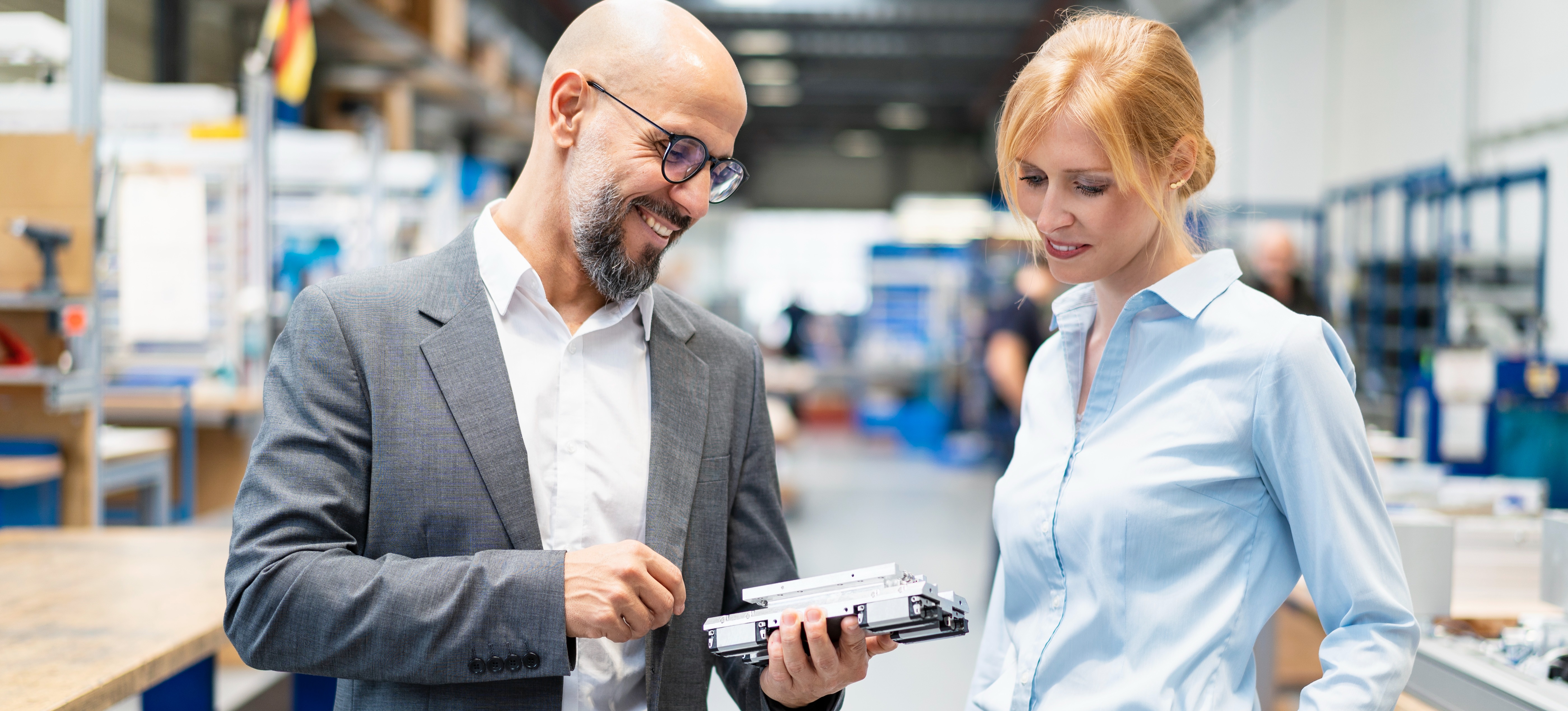 [Featured Image] Two quality engineers, who both work for a quality assurance salary, examine a workpiece in the factory.
