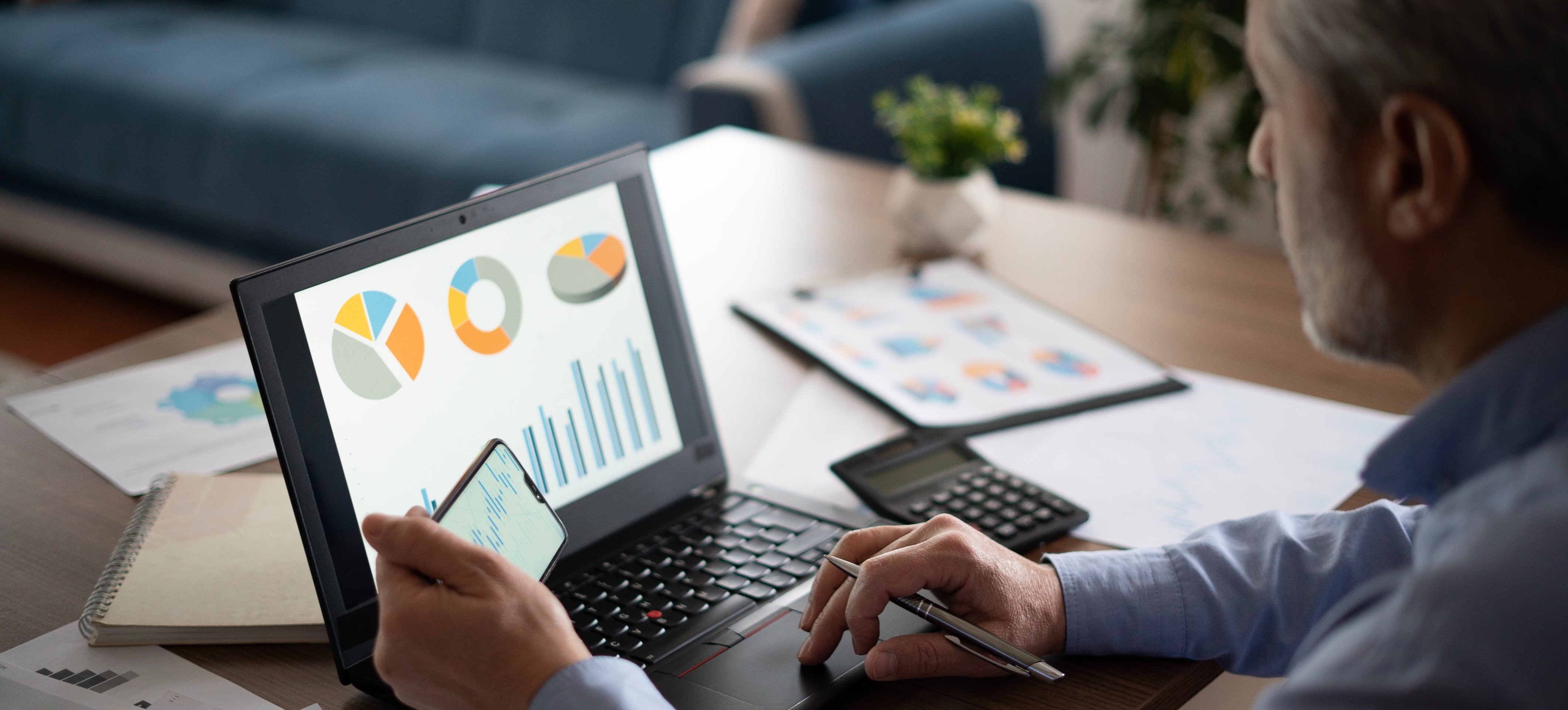 [Featured Image] A data analyst with a job after MSc reviews graphs on a laptop in a comfortable office space.