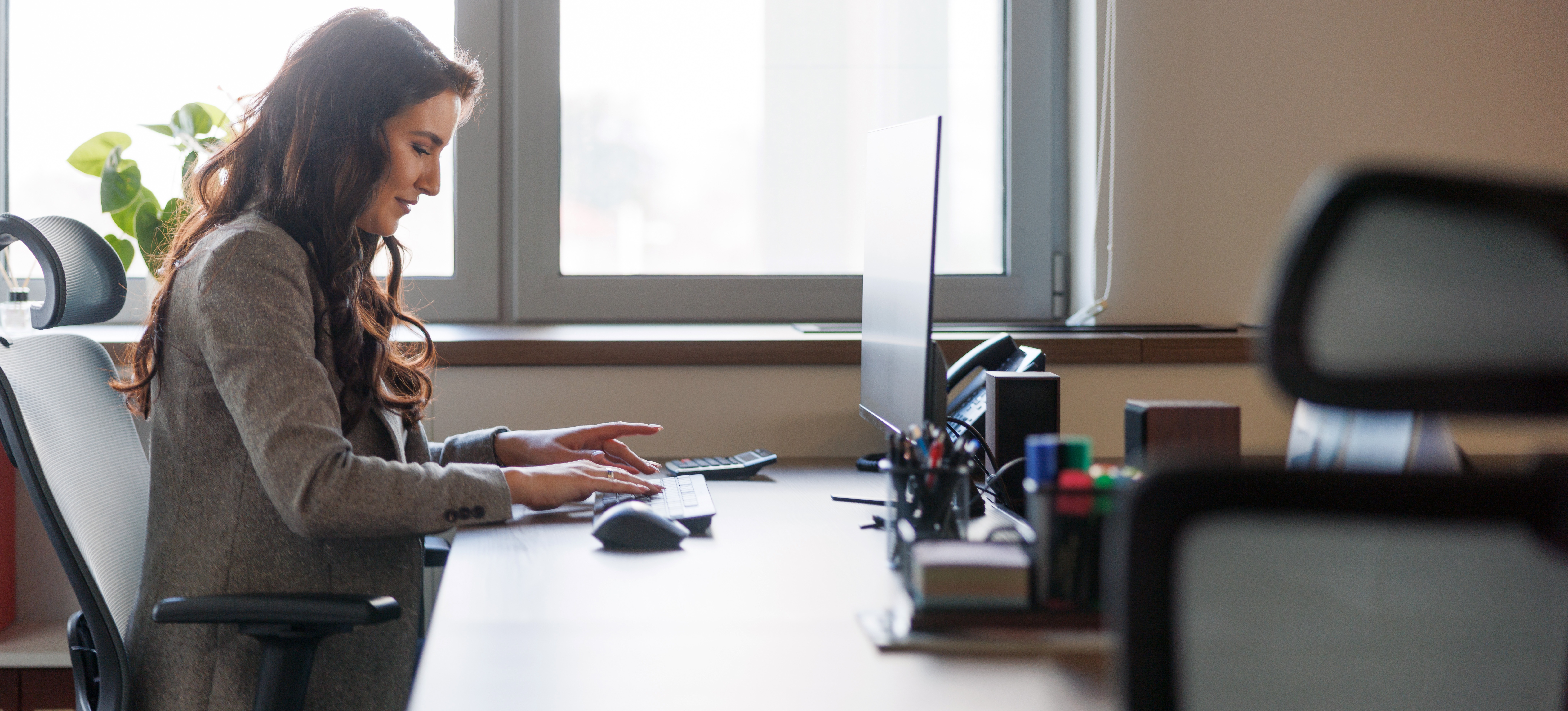 [Featured image: A business professional at their computer, using a Google Analytics cohort analysis to gain insights into consumer behavior.]
