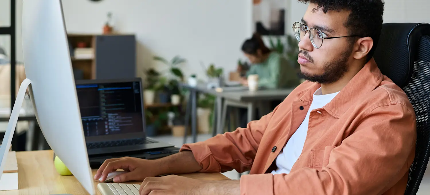 [Featured Image] A programmer works intently at a computer, applying DSA to write code in Java.