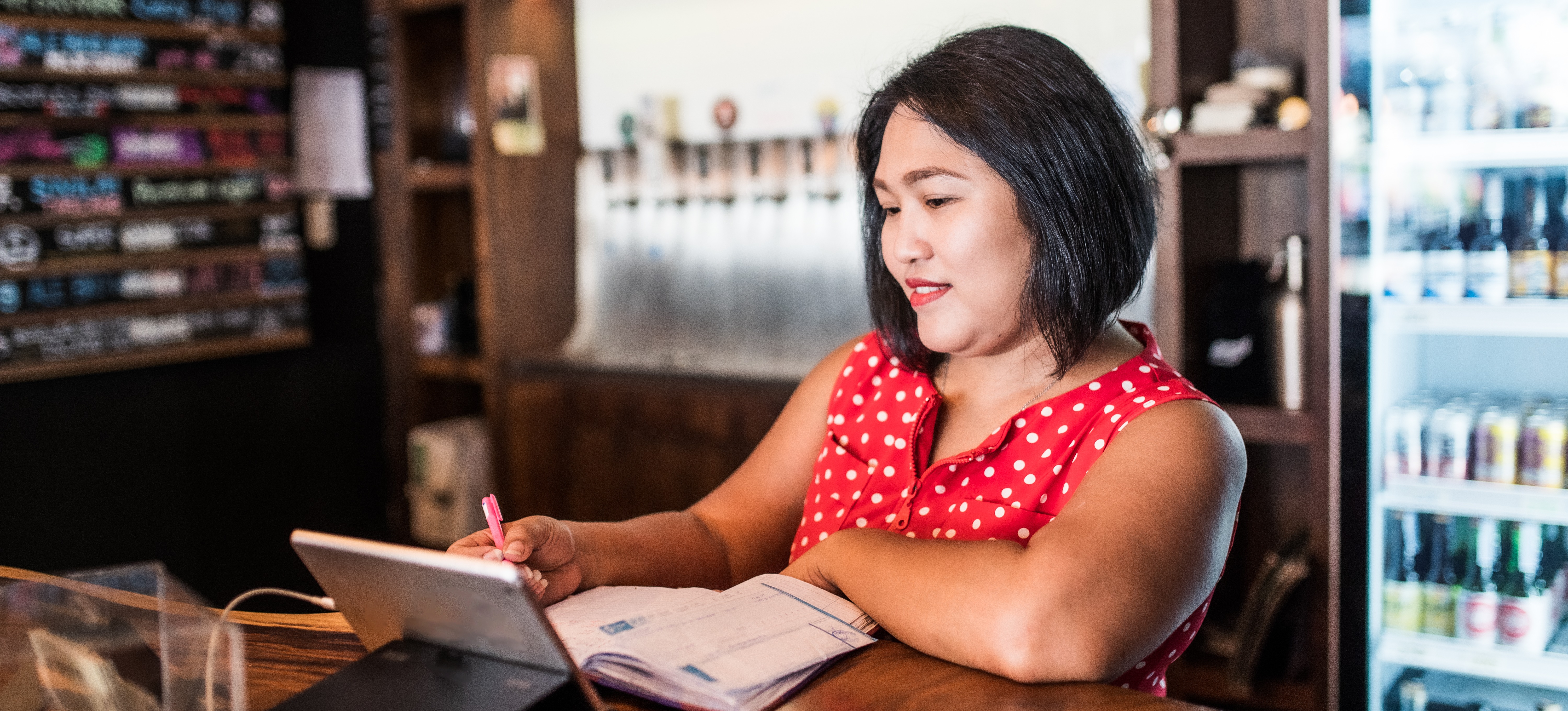 [Featured Image: Small business owner managing her books.]
